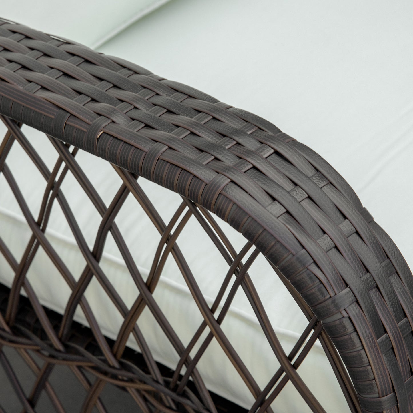 Dark brown wicker patio chair armrest with white cushion detail