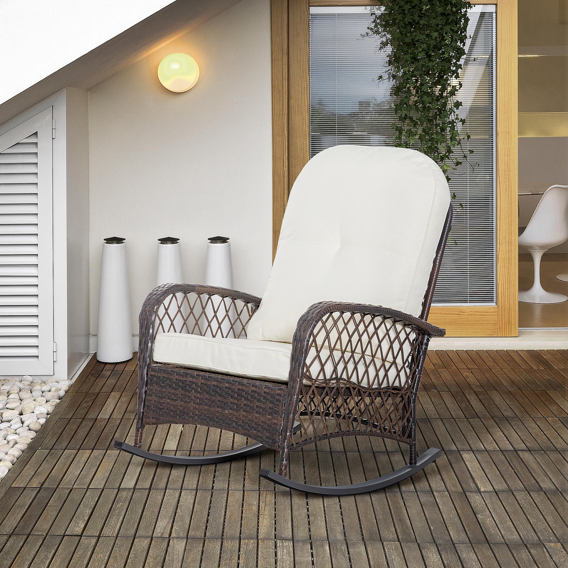 Brown wicker rocking chair with cream cushions on a wooden deck perfect for outdoor relaxation