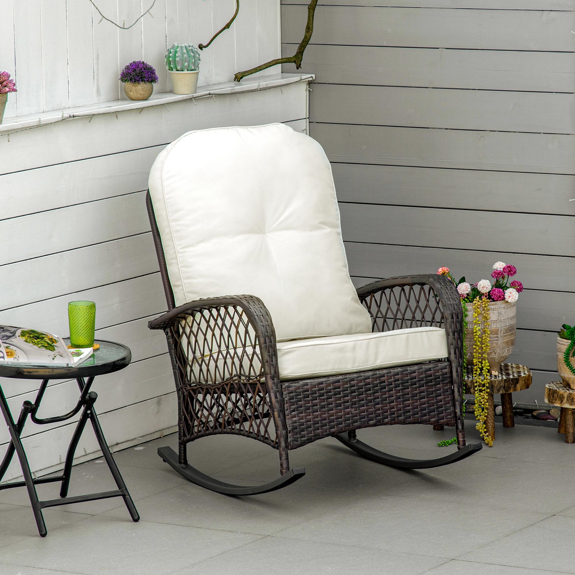Dark brown rattan rocking chair with plush cream cushions ideal for patio relaxation