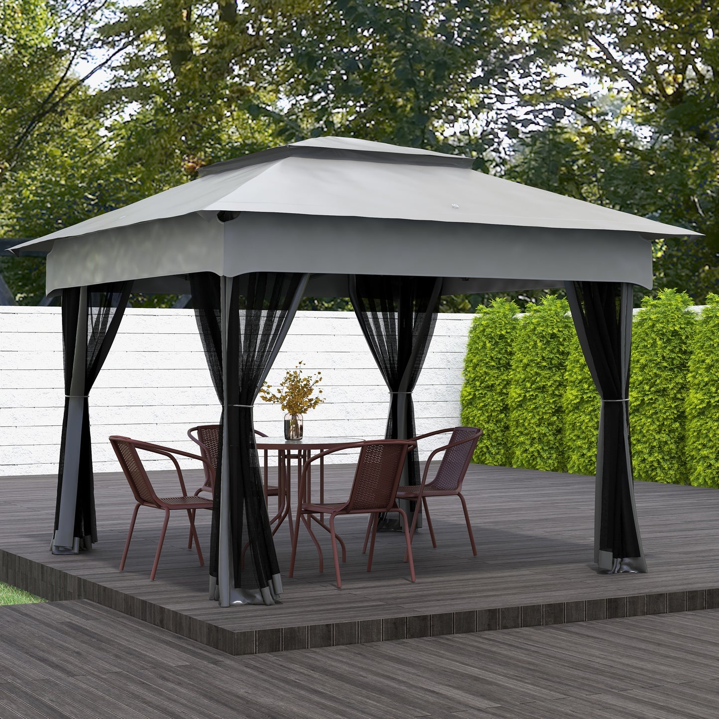 Grey outdoor gazebo with black mesh curtains and a patio table with chairs