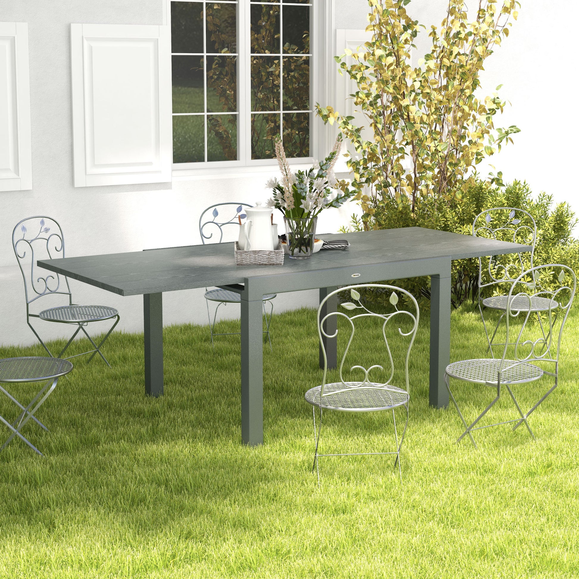 Gray metal patio table with ornate wrought iron chairs perfect for outdoor dining