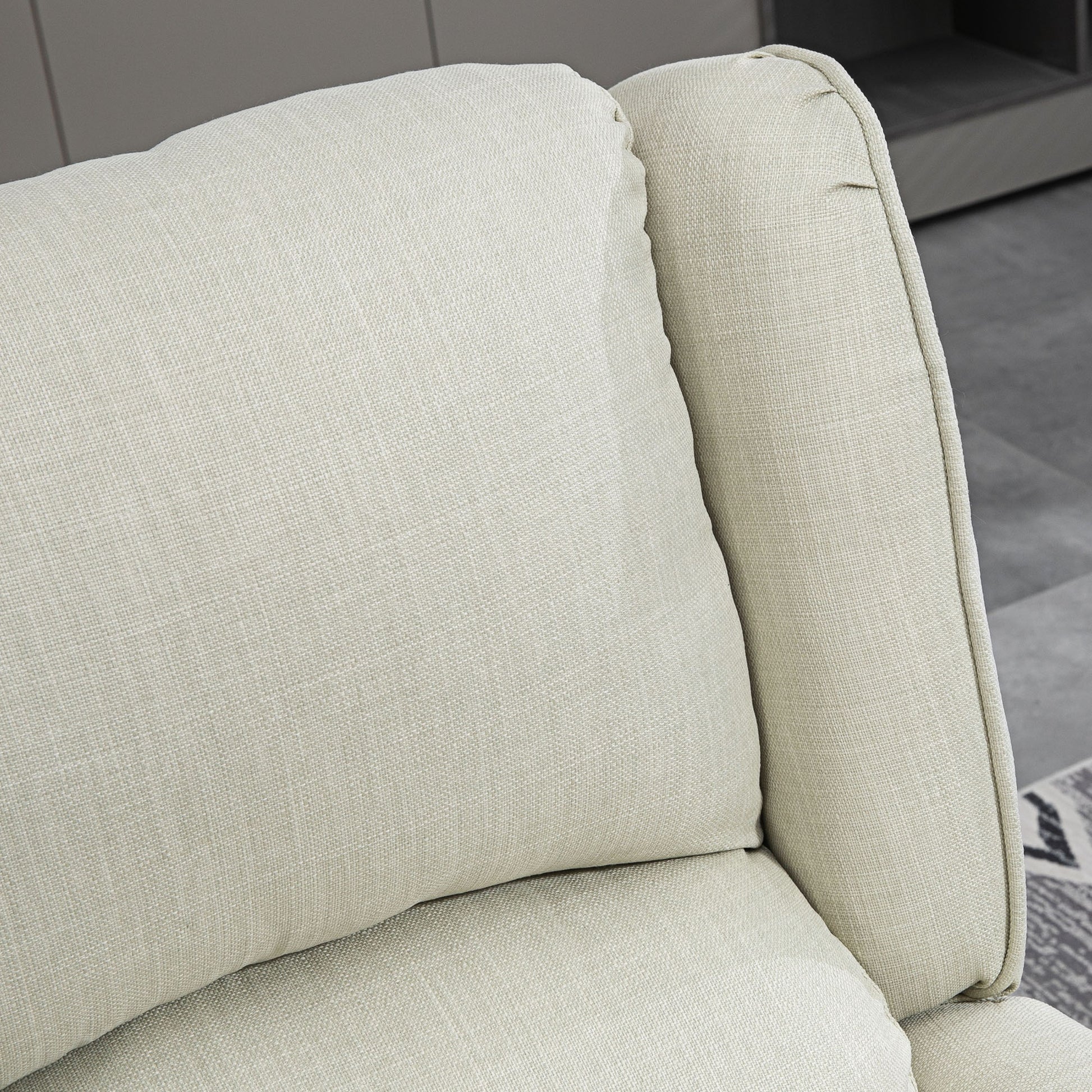 Closeup of a textured beige linen couch cushion and armrest offering a cozy feel