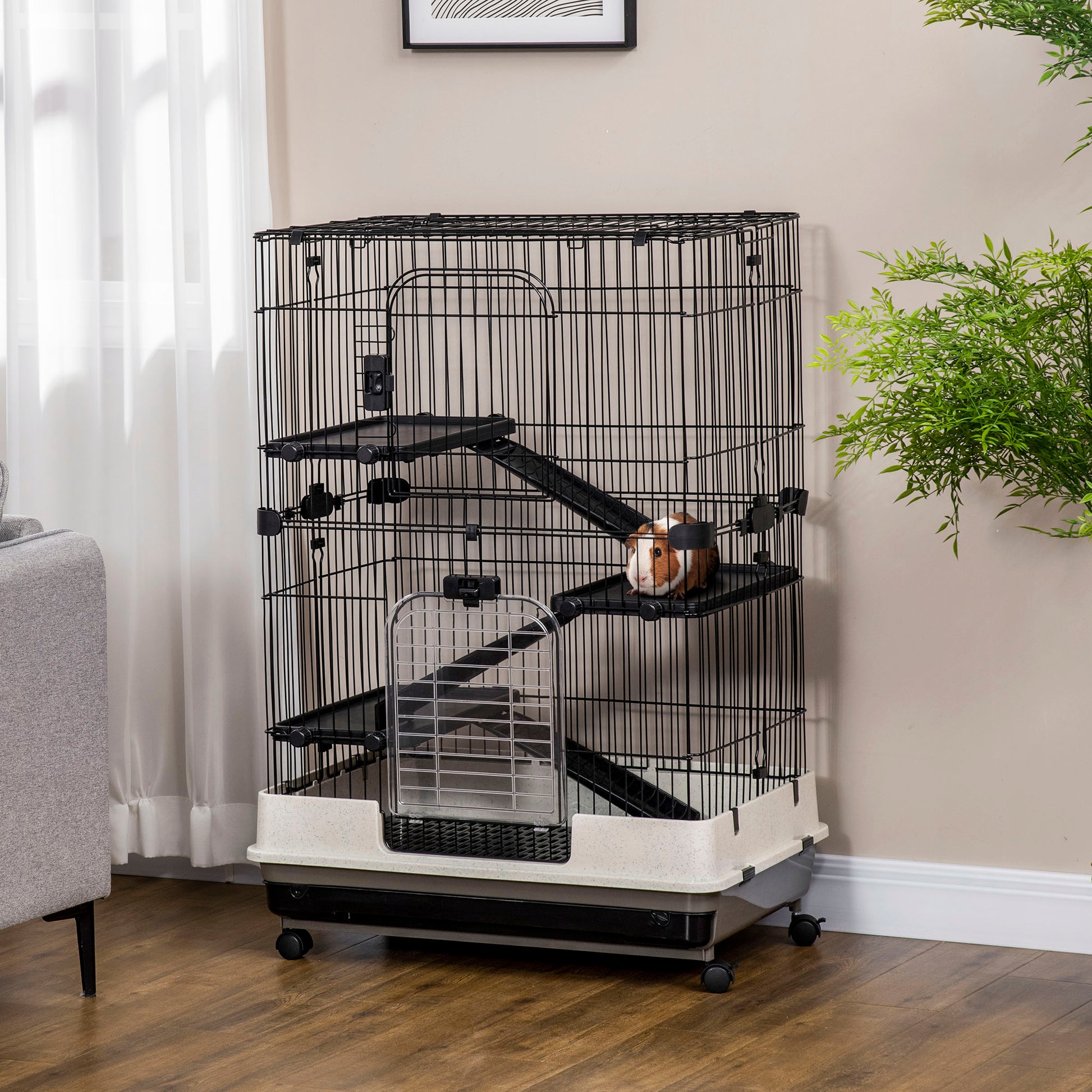 Multilevel black wire small animal cage with ramps and a guinea pig resting on a platform