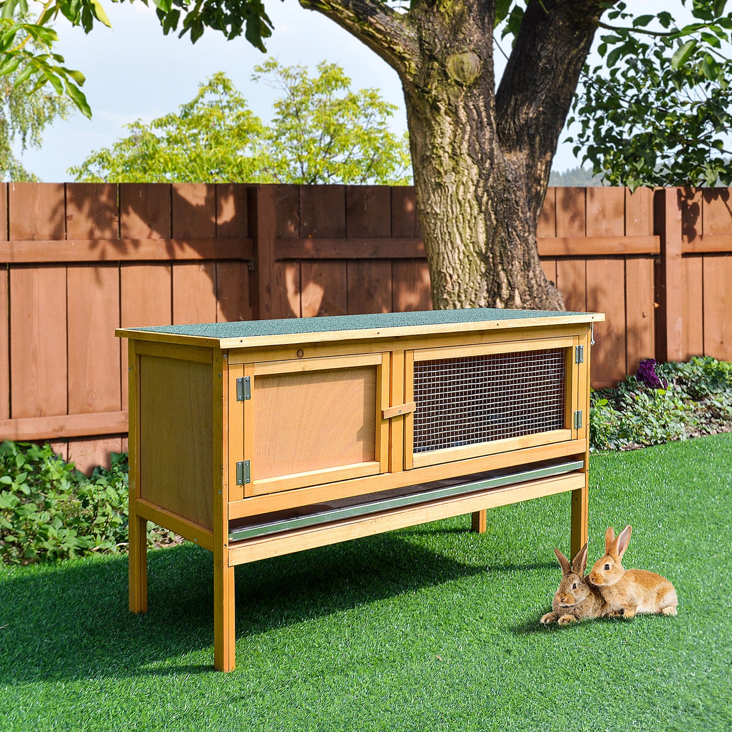 Wooden rabbit hutch with two compartments and wire mesh door on green lawn