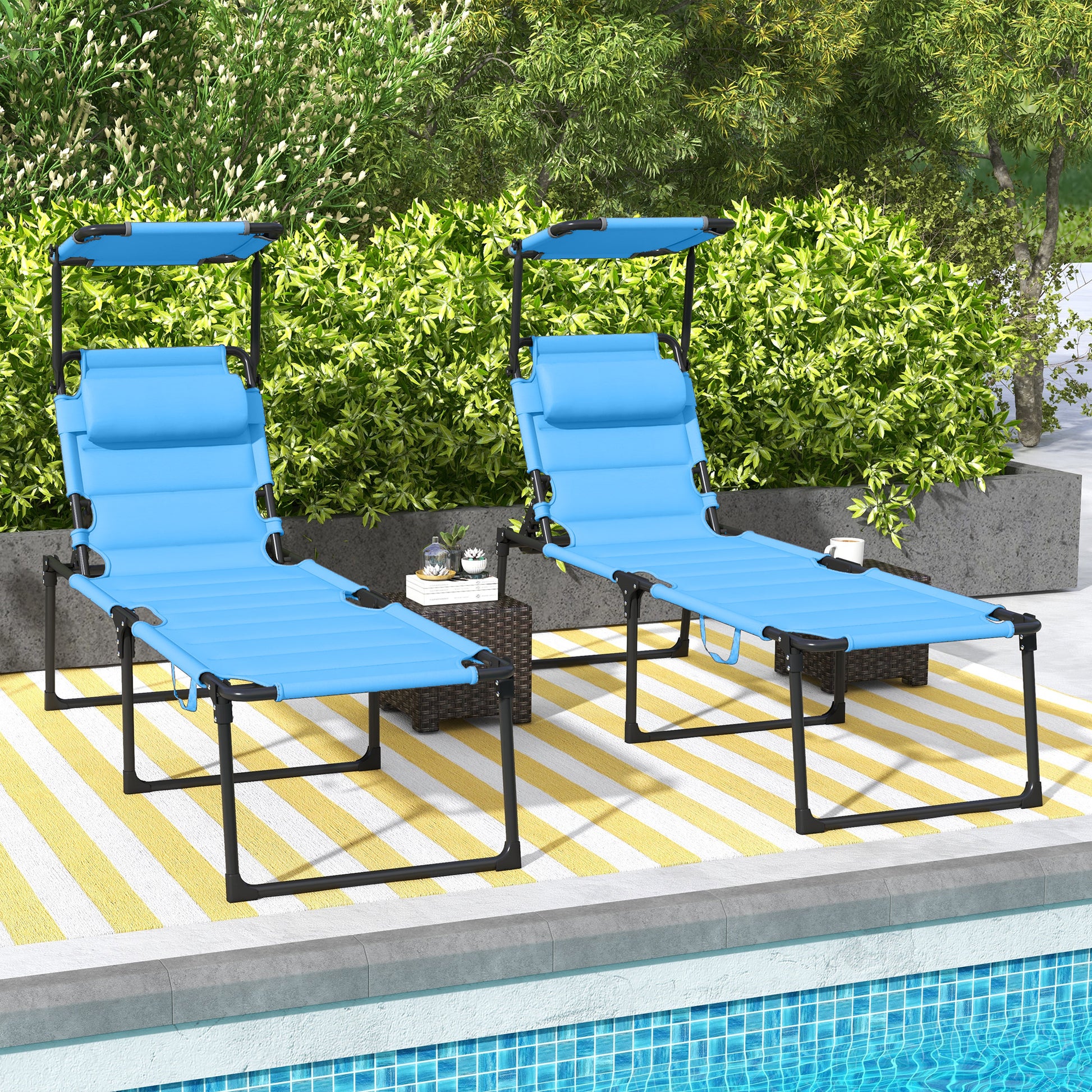 Two blue portable lounge chairs with canopies sit poolside on a striped rug