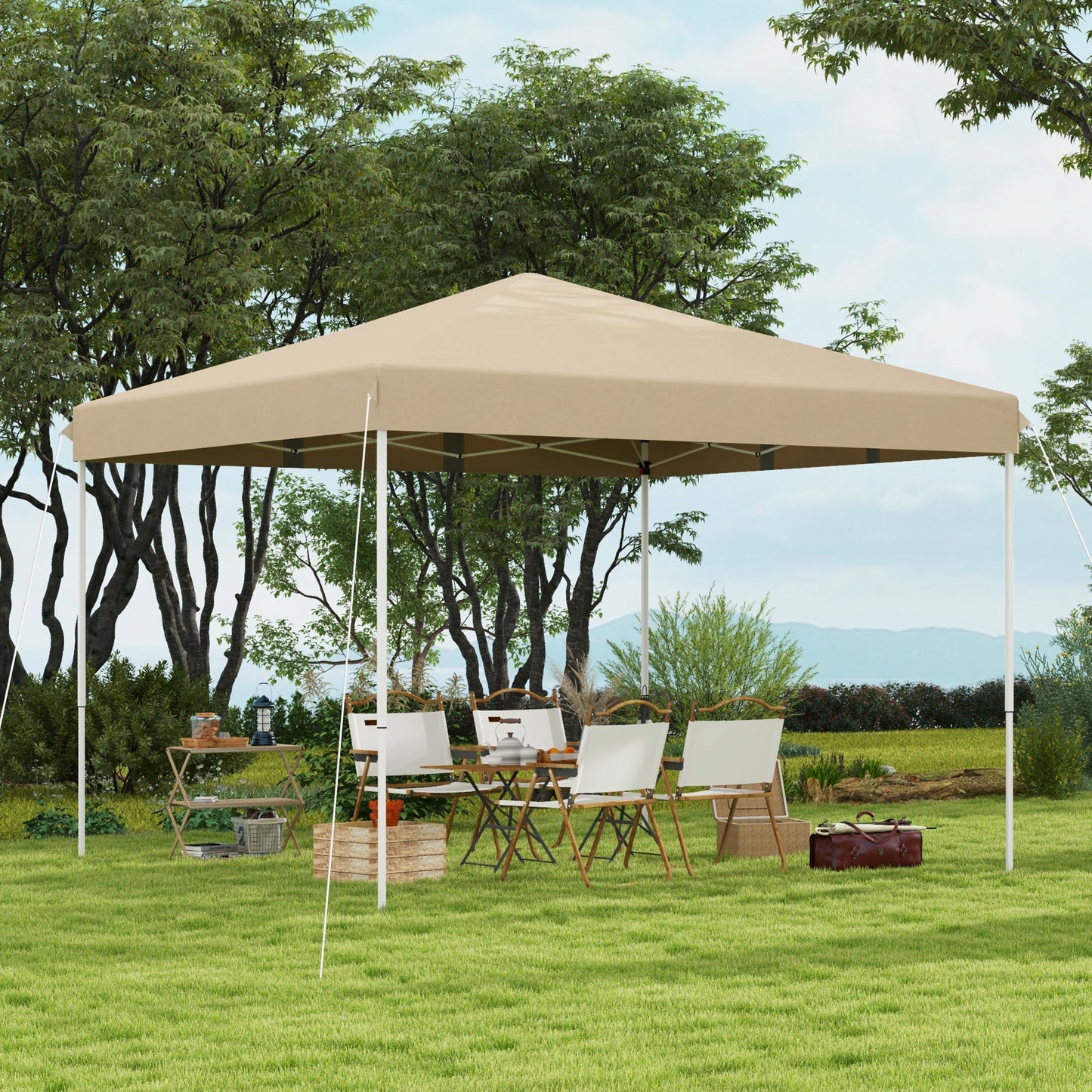 Khaki instant canopy tent set up in a grassy yard with chairs and a table