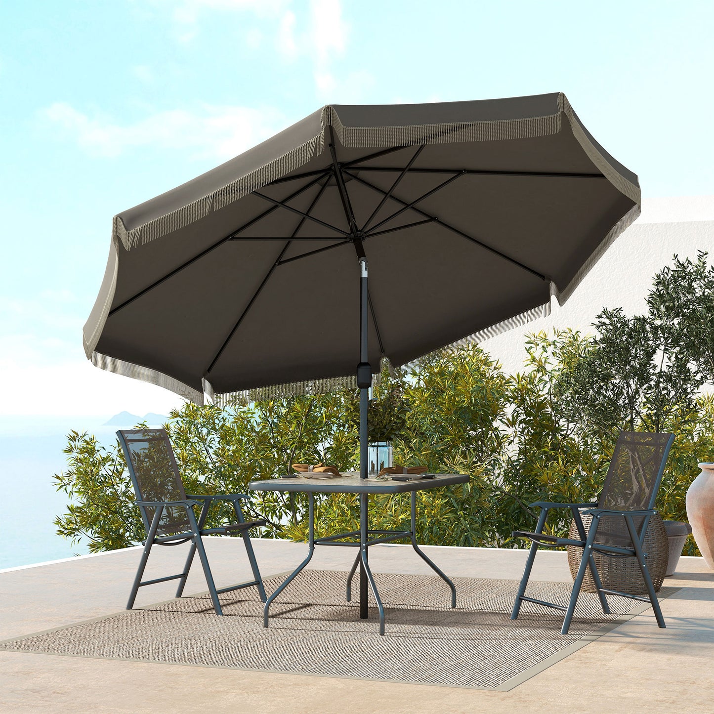 Dark grey patio umbrella with fringe detail providing shade for outdoor seating