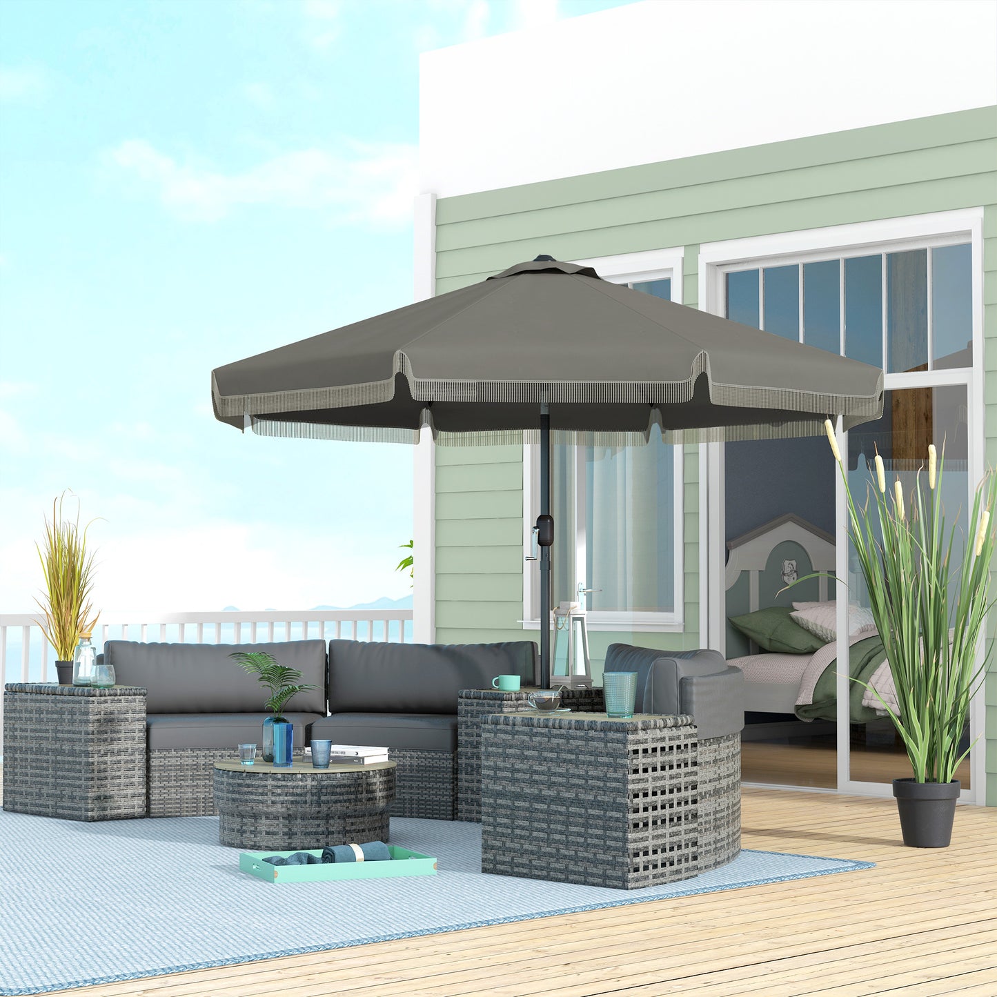 Grey rattan sectional sofa with plush cushions and matching coffee tables on a deck