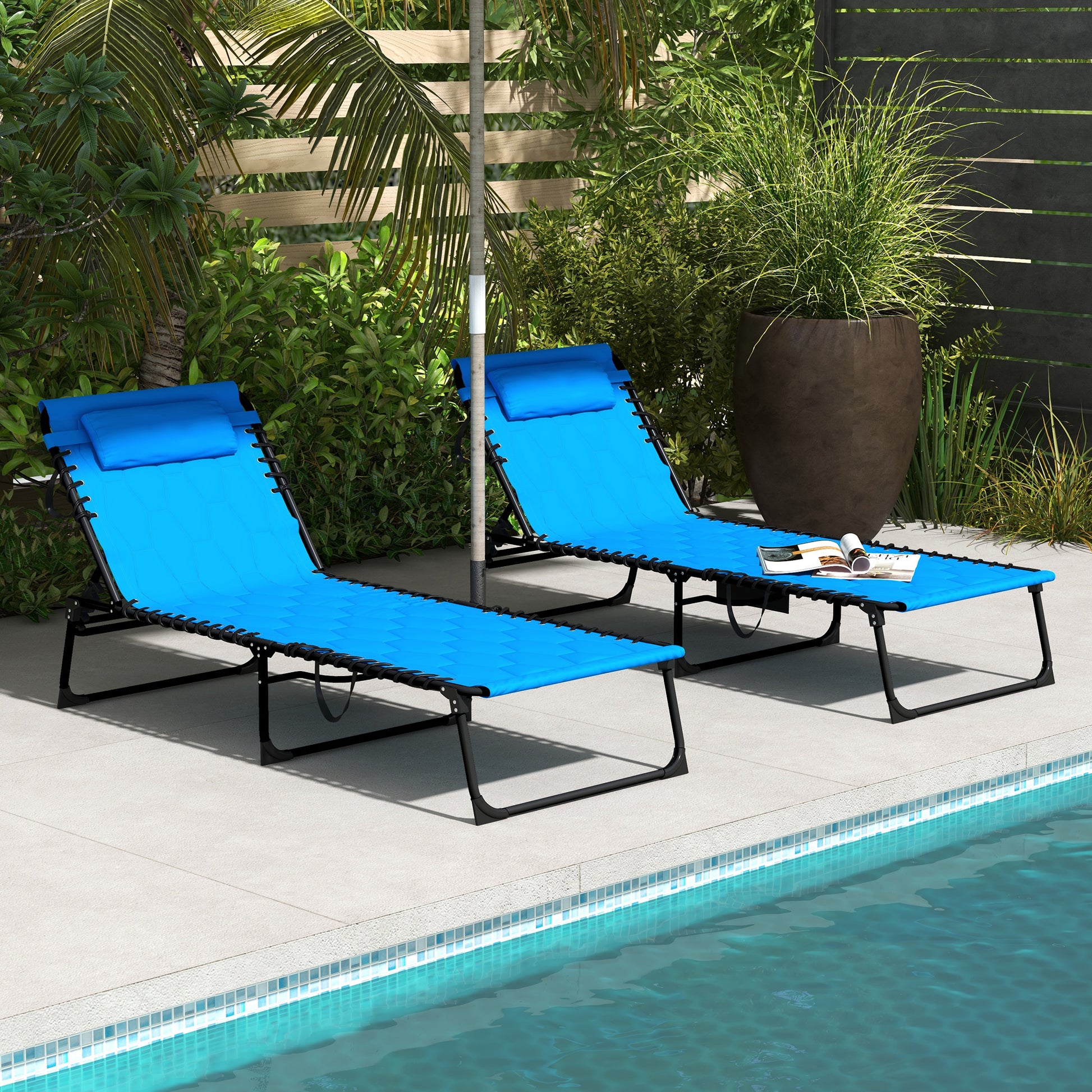 Two blue foldable lounge chairs with pillows poolside