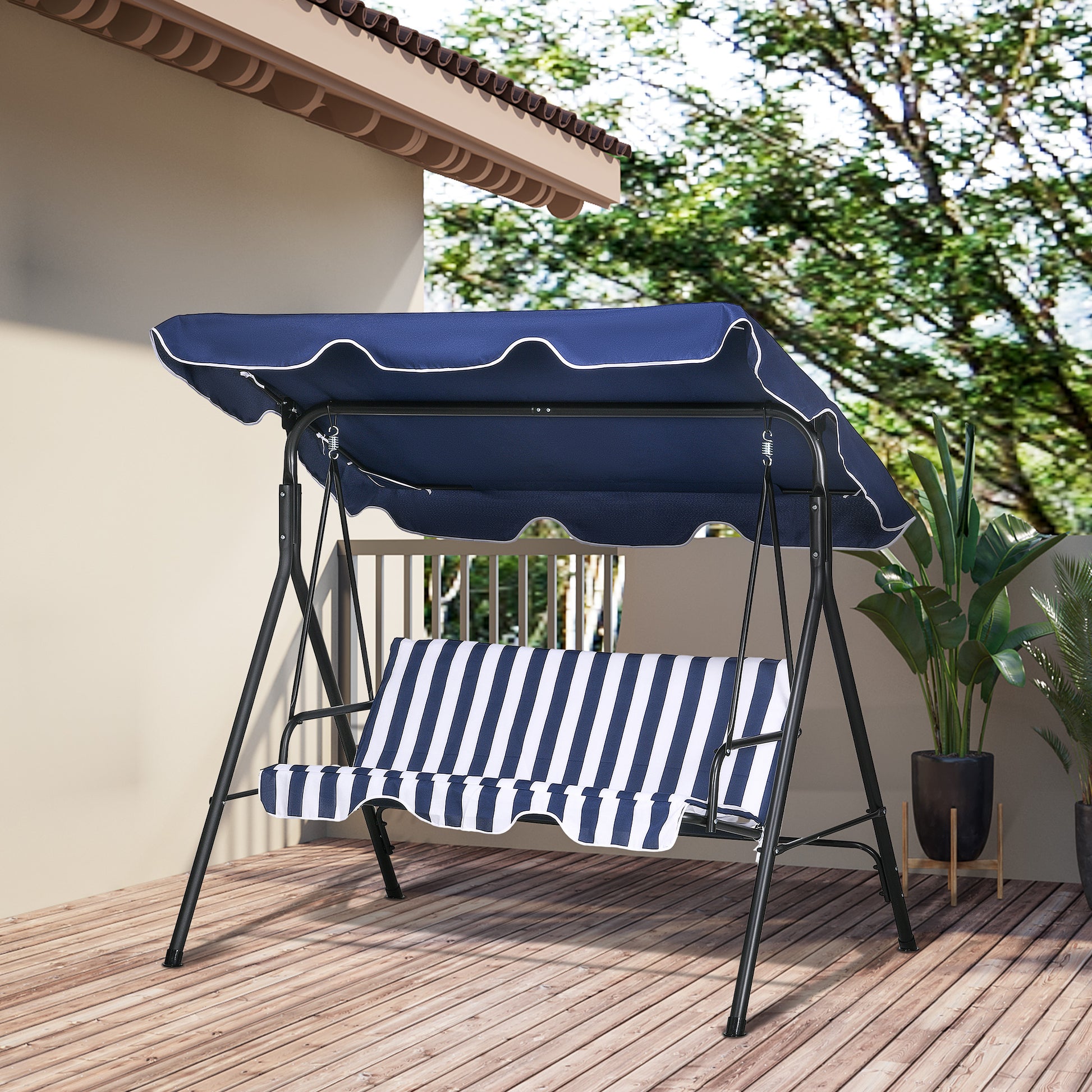 Navy blue outdoor swing with white piping and striped cushions on a wooden deck
