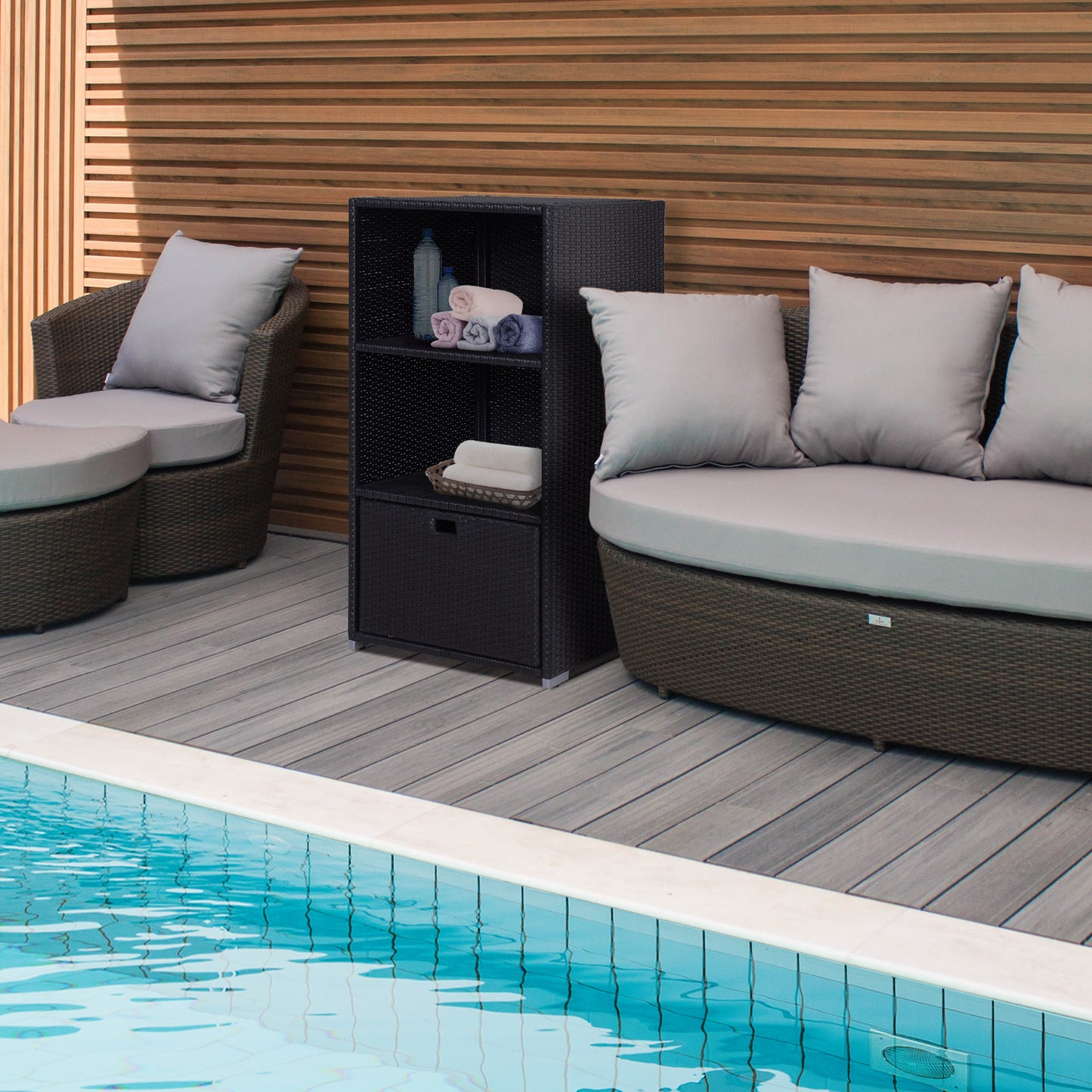 Black rattan storage cabinet with shelves holding towels and bottles