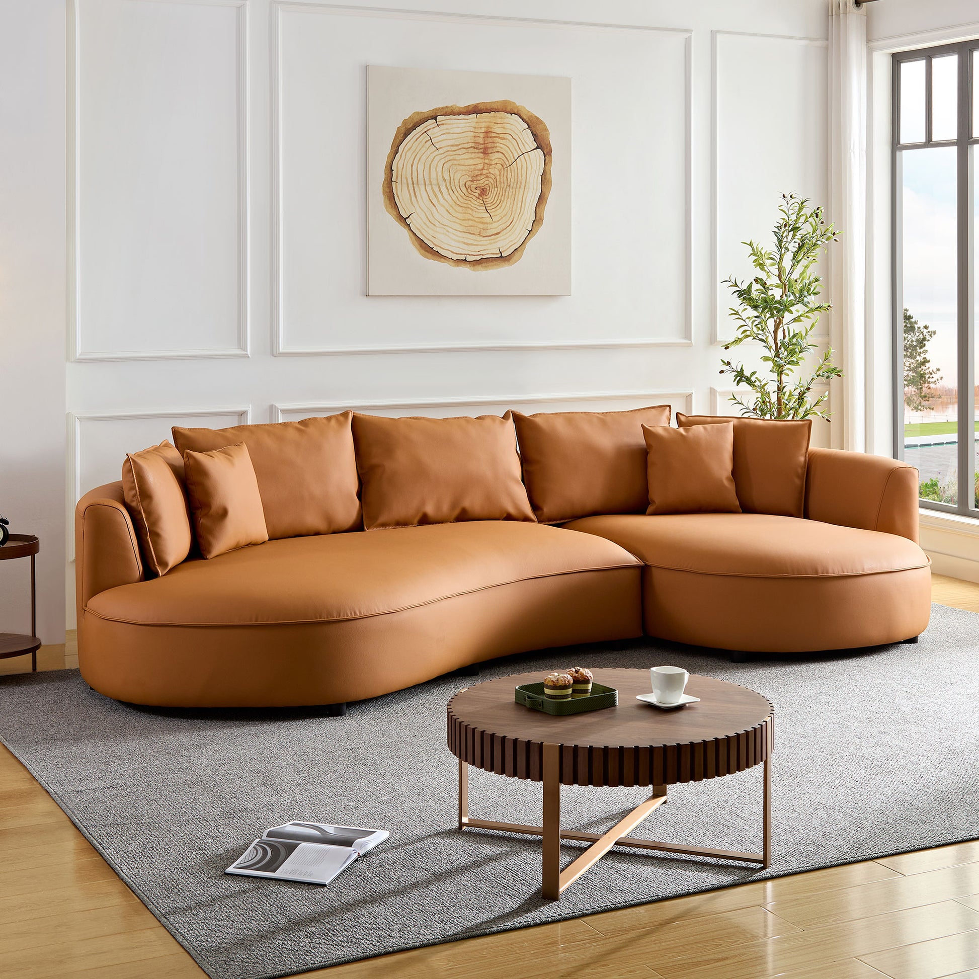 Curved sectional sofa in caramel vegan leather with plush throw pillows for a modern living room