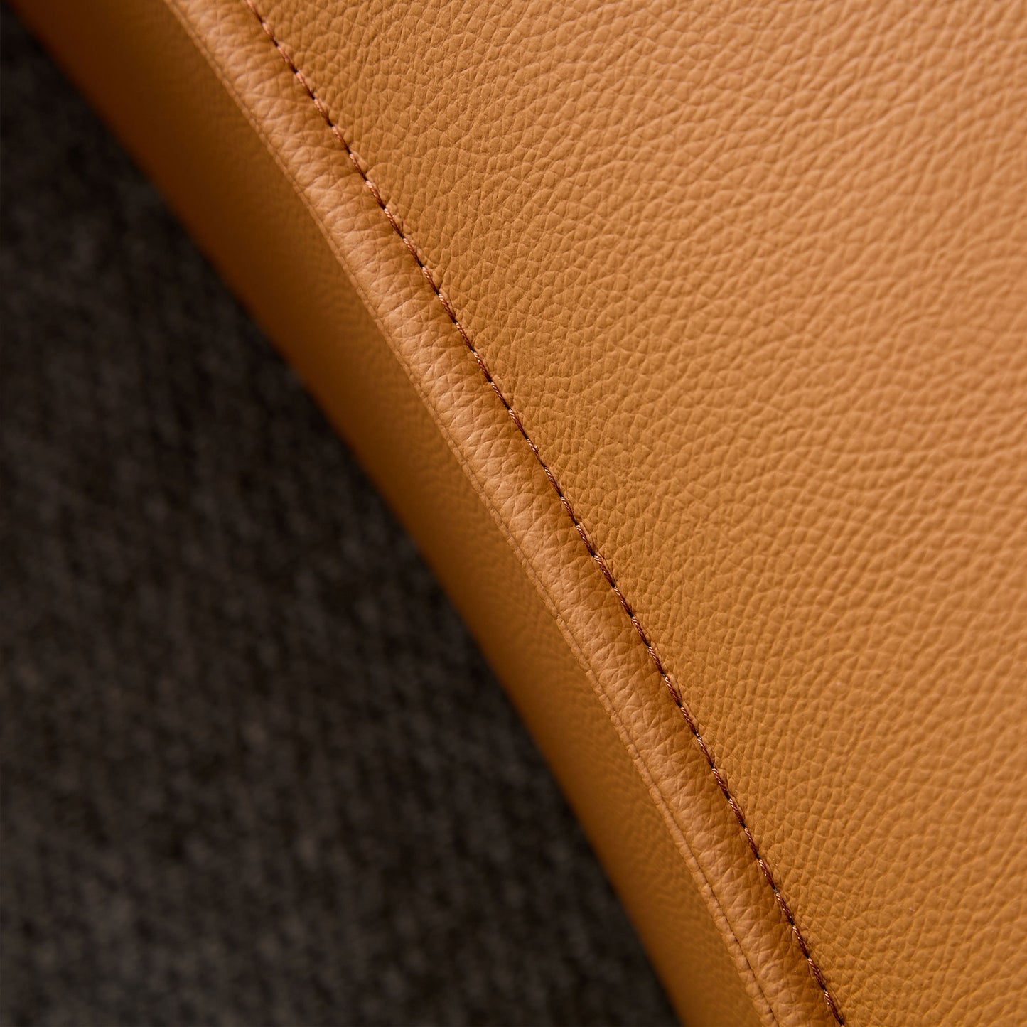 Closeup of tan genuine leather texture with detailed stitching perfect for luxury furniture