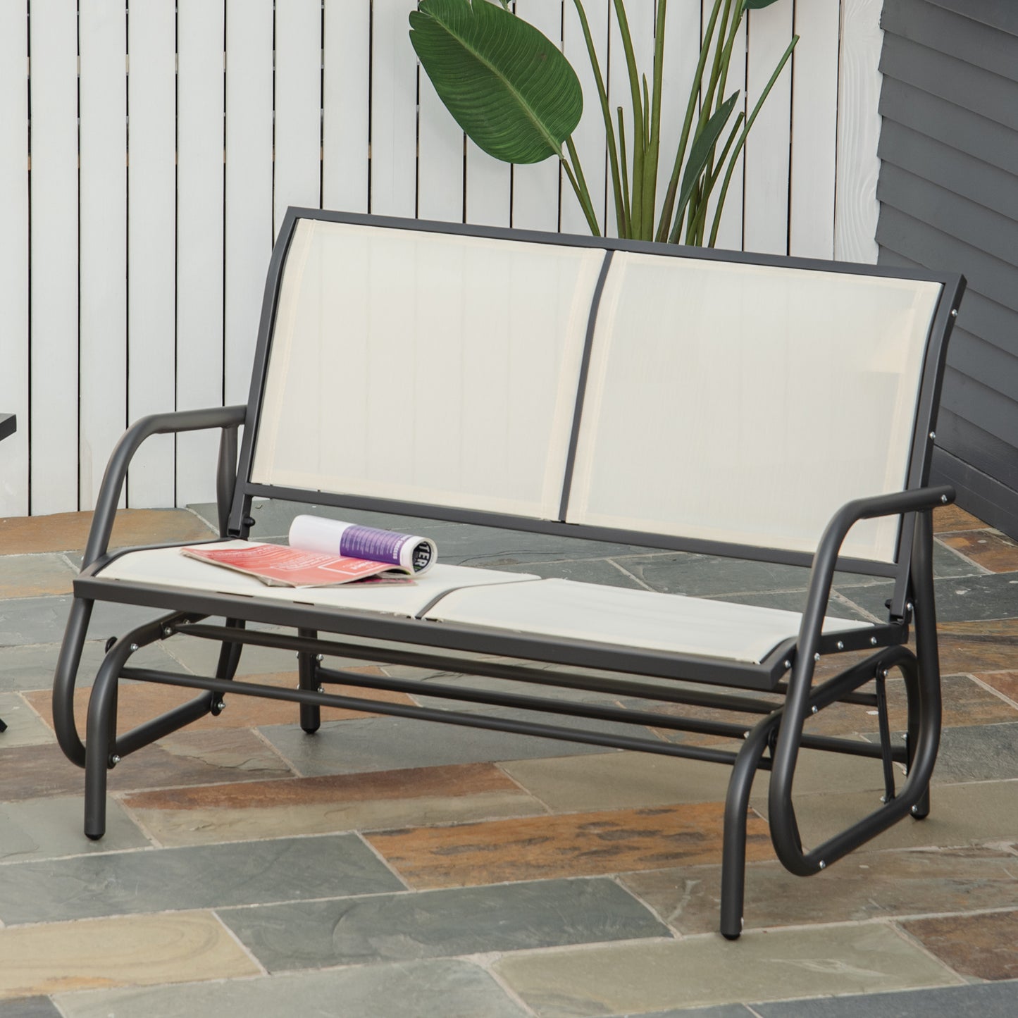 Dark gray metal outdoor glider bench with beige fabric seat and back