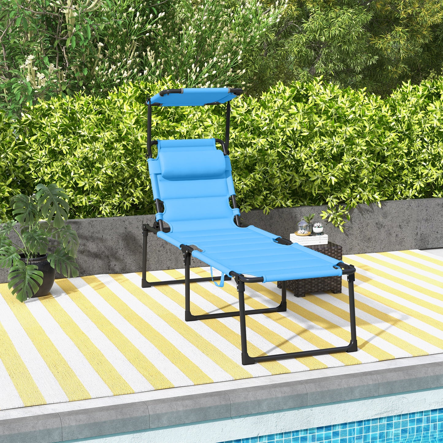 Blue adjustable chaise lounge with canopy on yellow striped rug near pool
