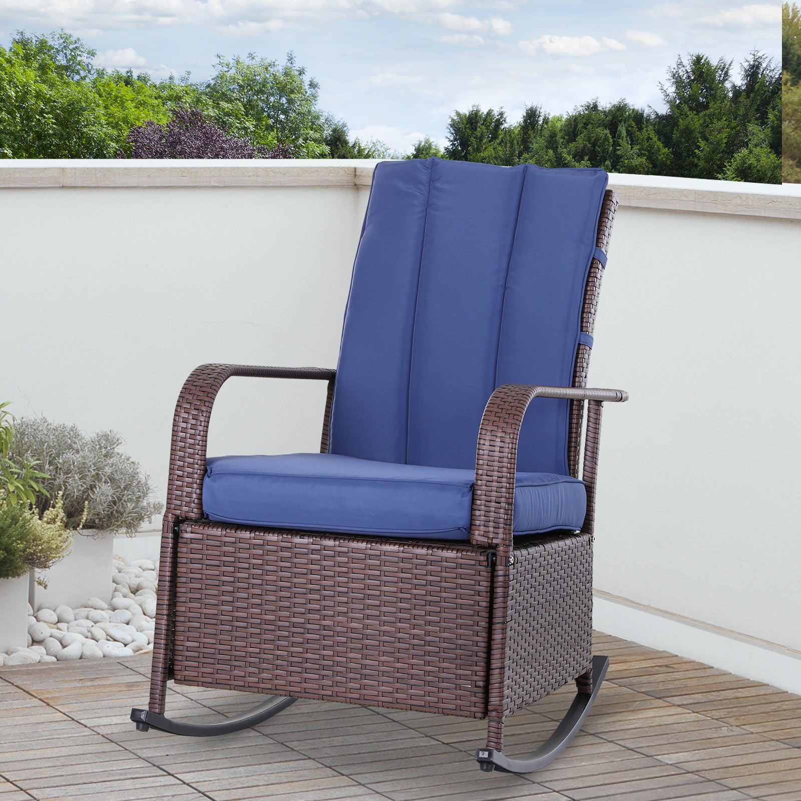Brown wicker rocking chair with plush blue cushions on a wooden deck