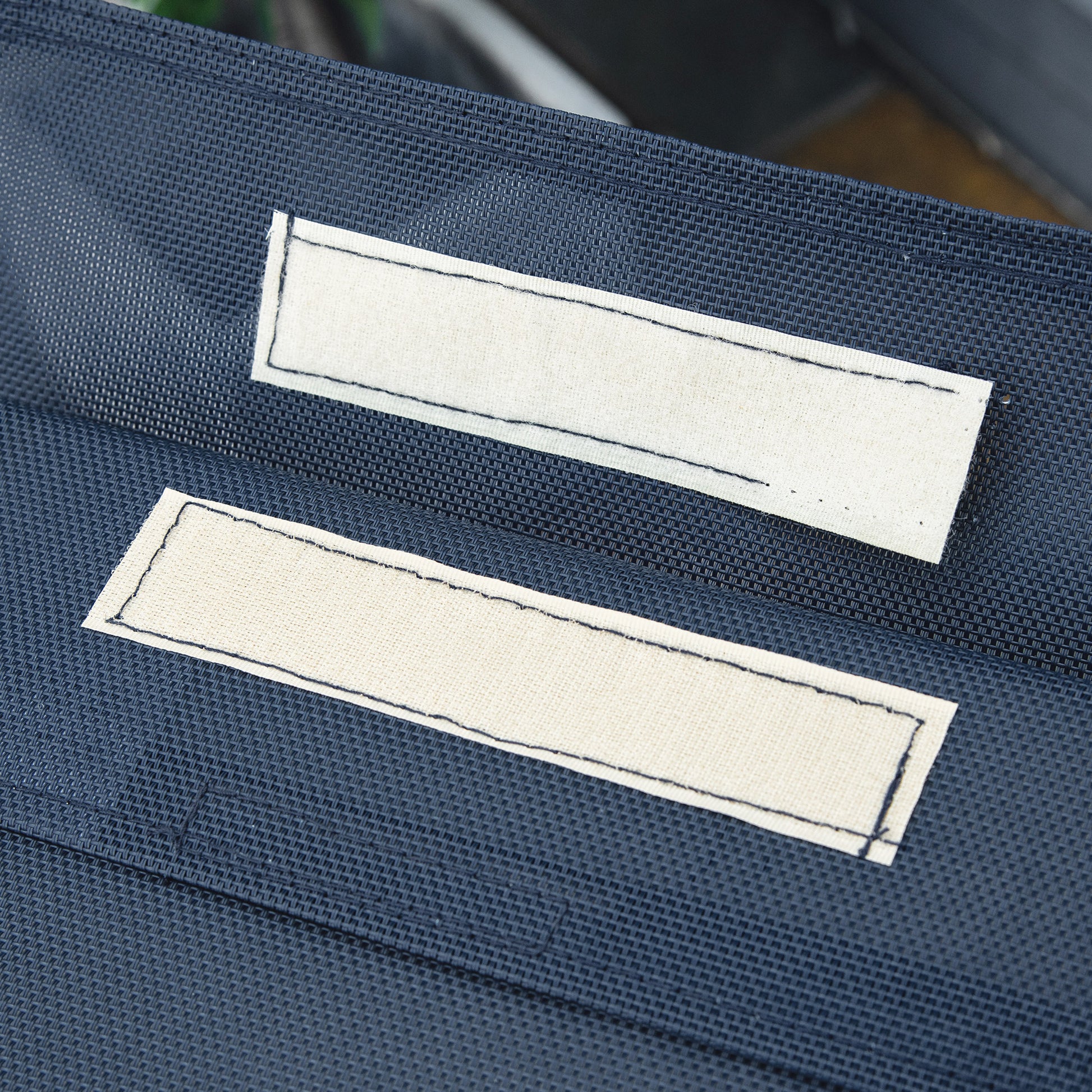 Dark blue fabric with two beige rectangular patches likely for customization
