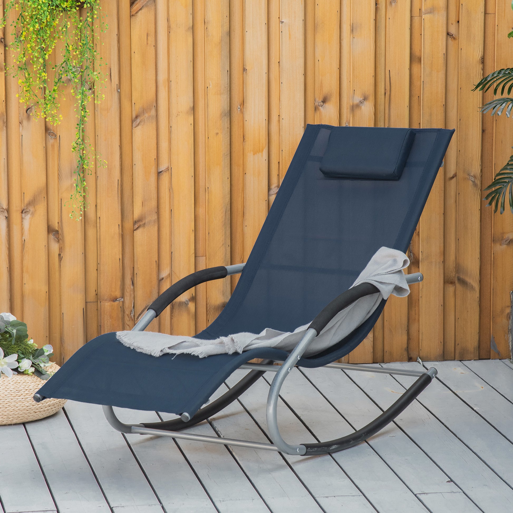 Dark blue rocking lounge chair with silver frame and pillow on deck