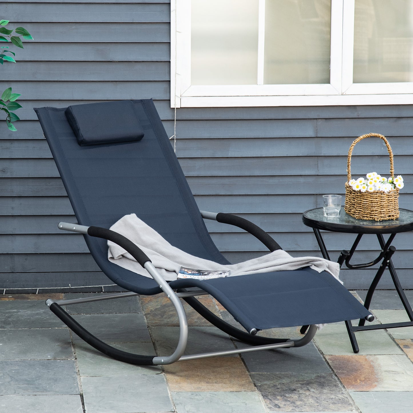 Navy blue outdoor rocking lounge chair with gray metal frame and pillow