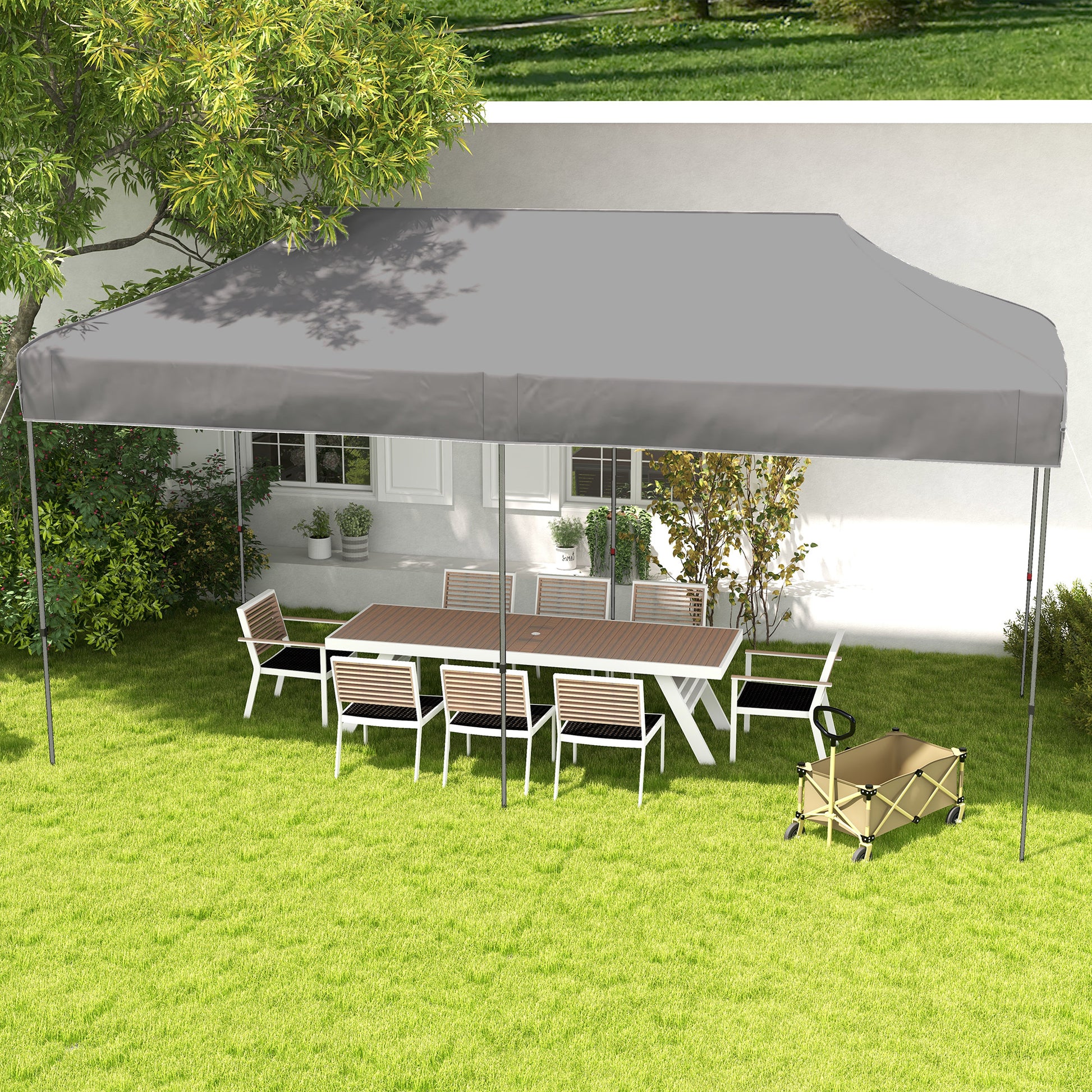 Gray outdoor canopy tent with white frame over a patio dining set on lush green grass