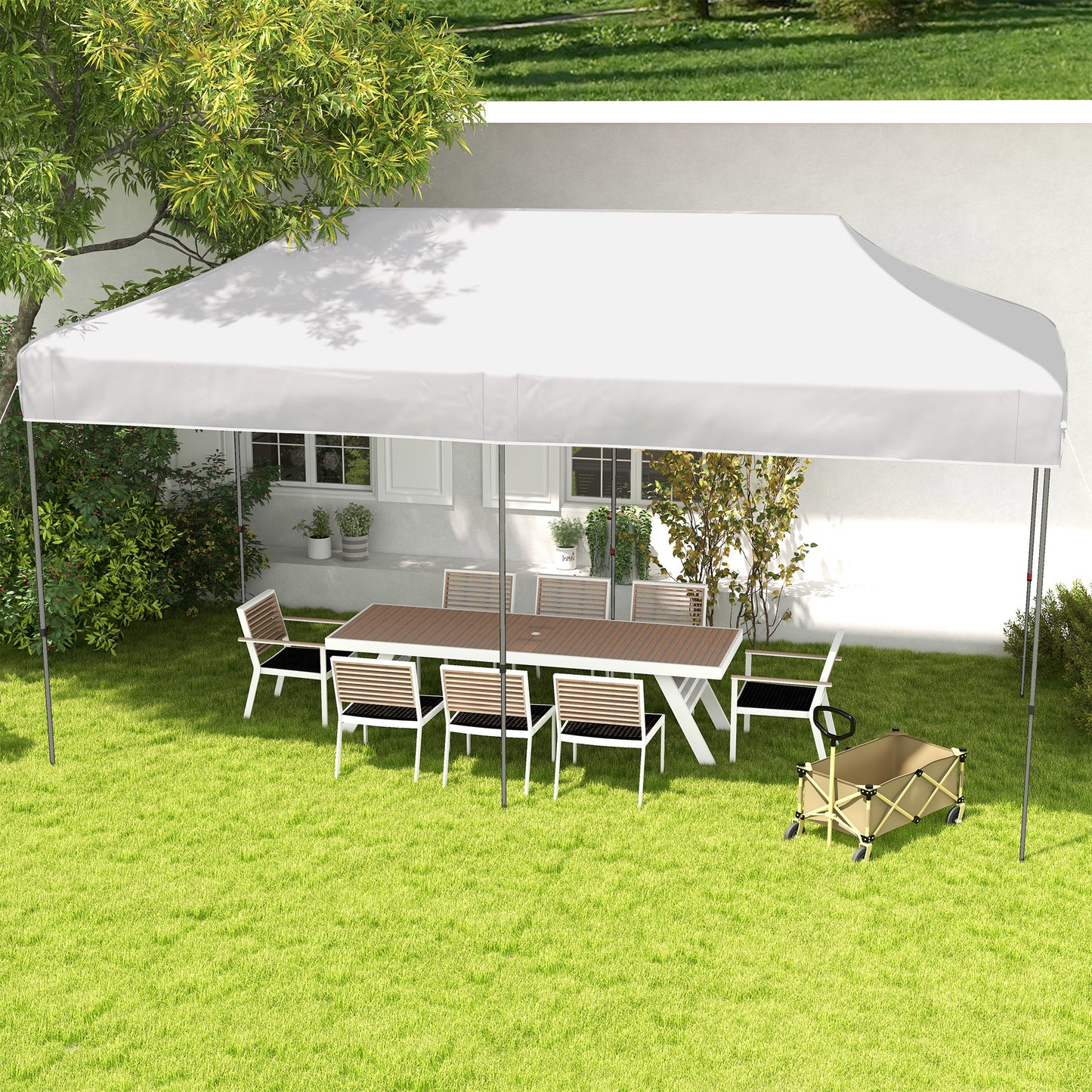 White canopy tent covering a wooden picnic table with chairs on lush green grass