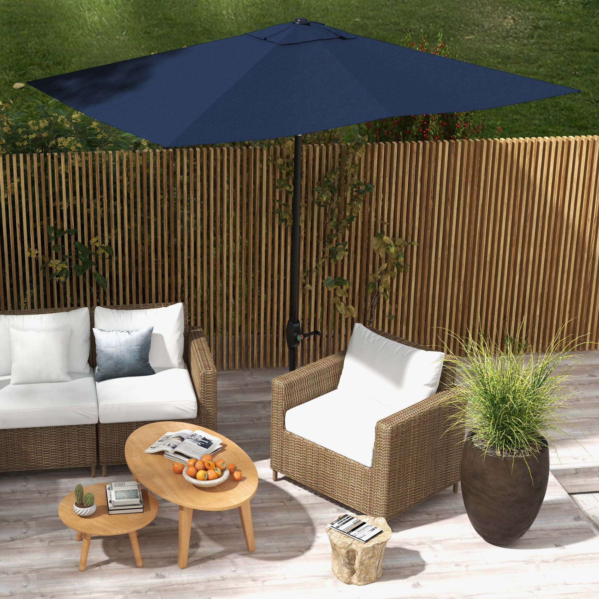 Navy blue patio umbrella providing shade for a wicker outdoor furniture set
