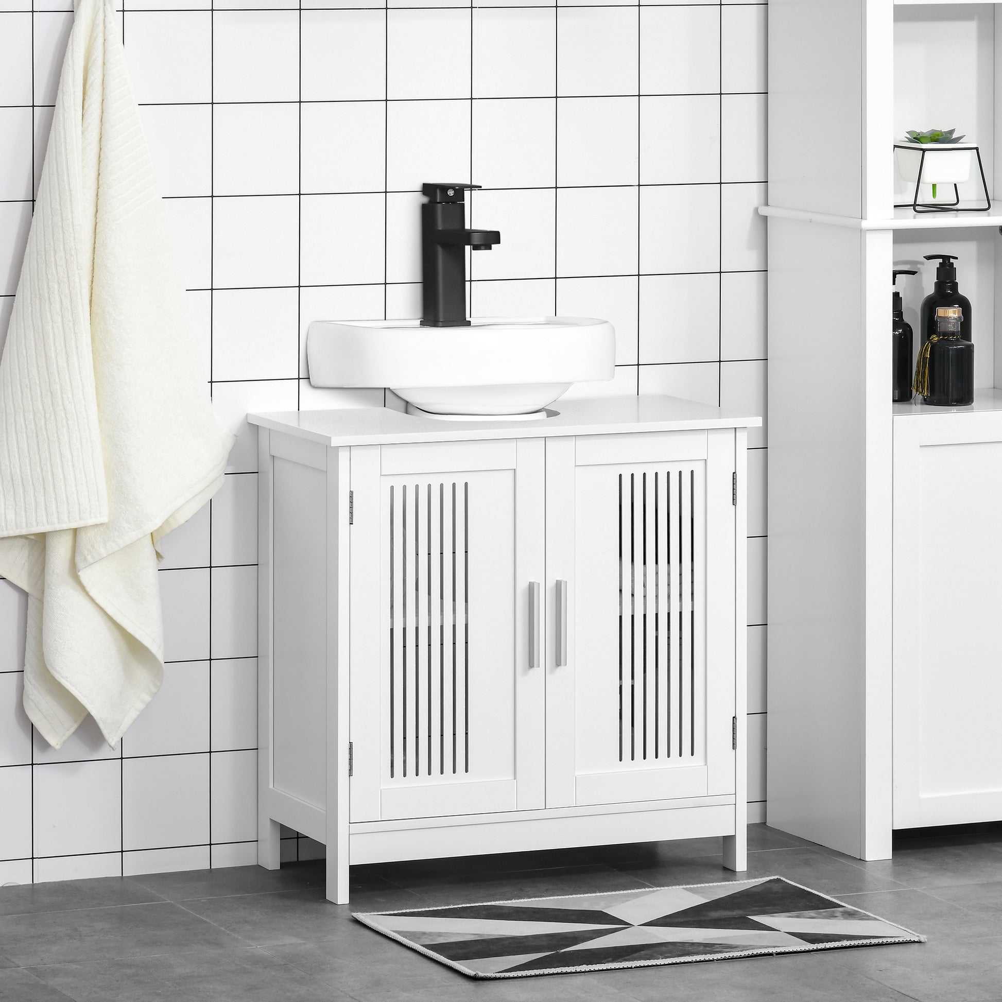 White bathroom vanity with slatted doors and chrome handles holding a white vessel sink
