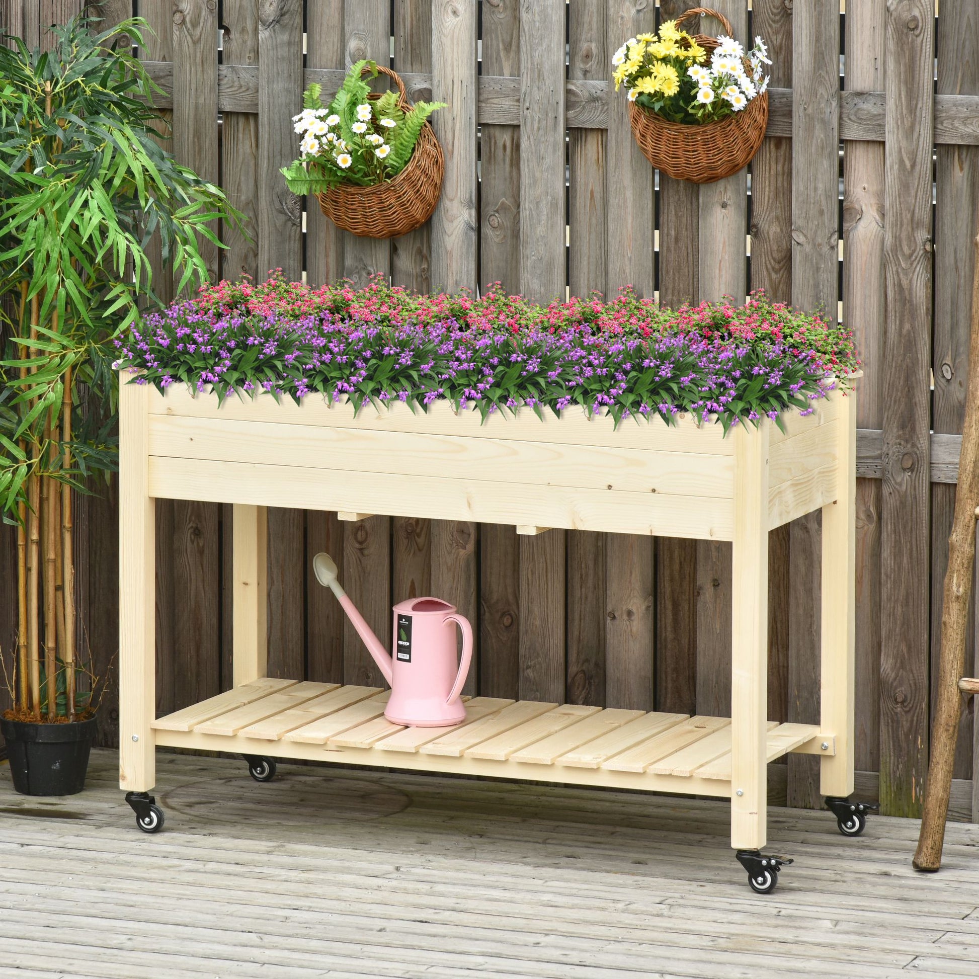 Wooden raised garden bed with wheels overflowing with pink and purple flowers