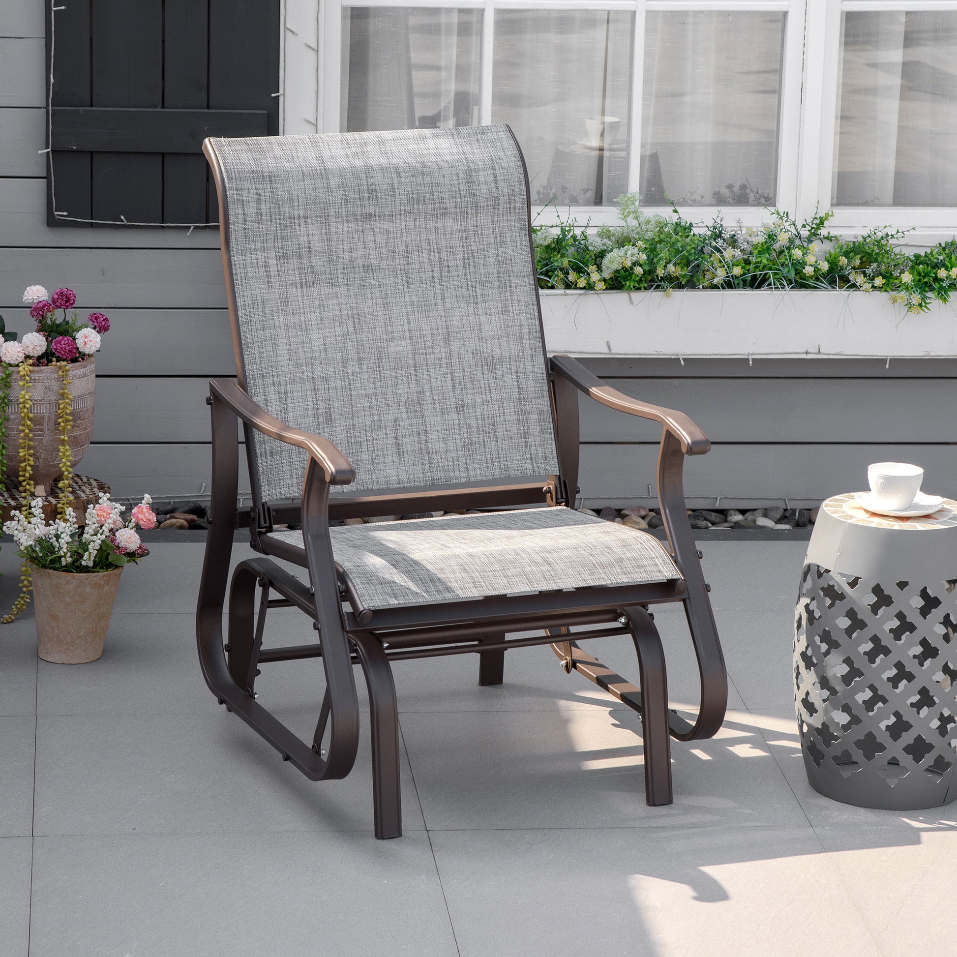Gray fabric patio glider chair with bronze metal frame and armrests