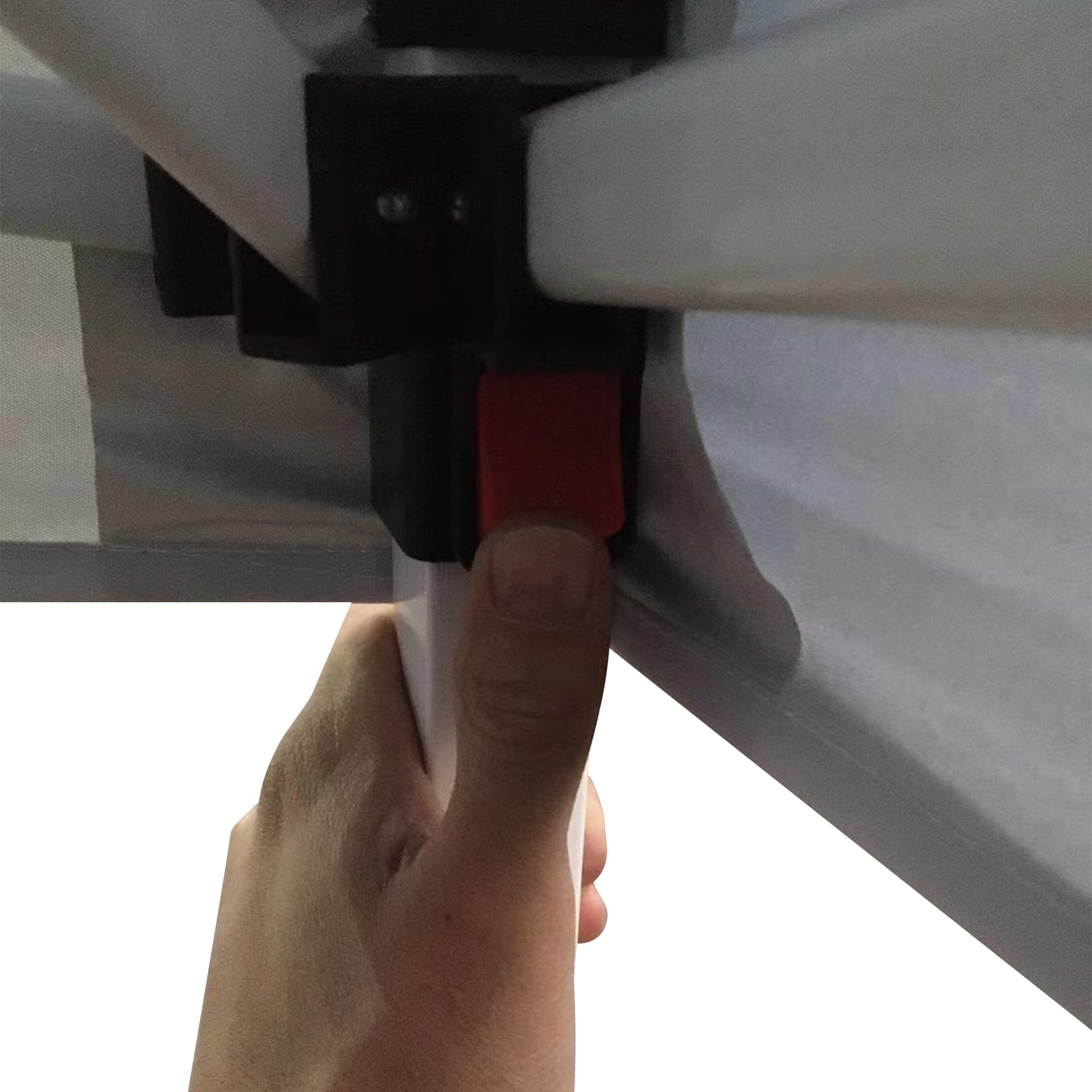 Closeup of a hand pressing a red button on a white tent frame mechanism