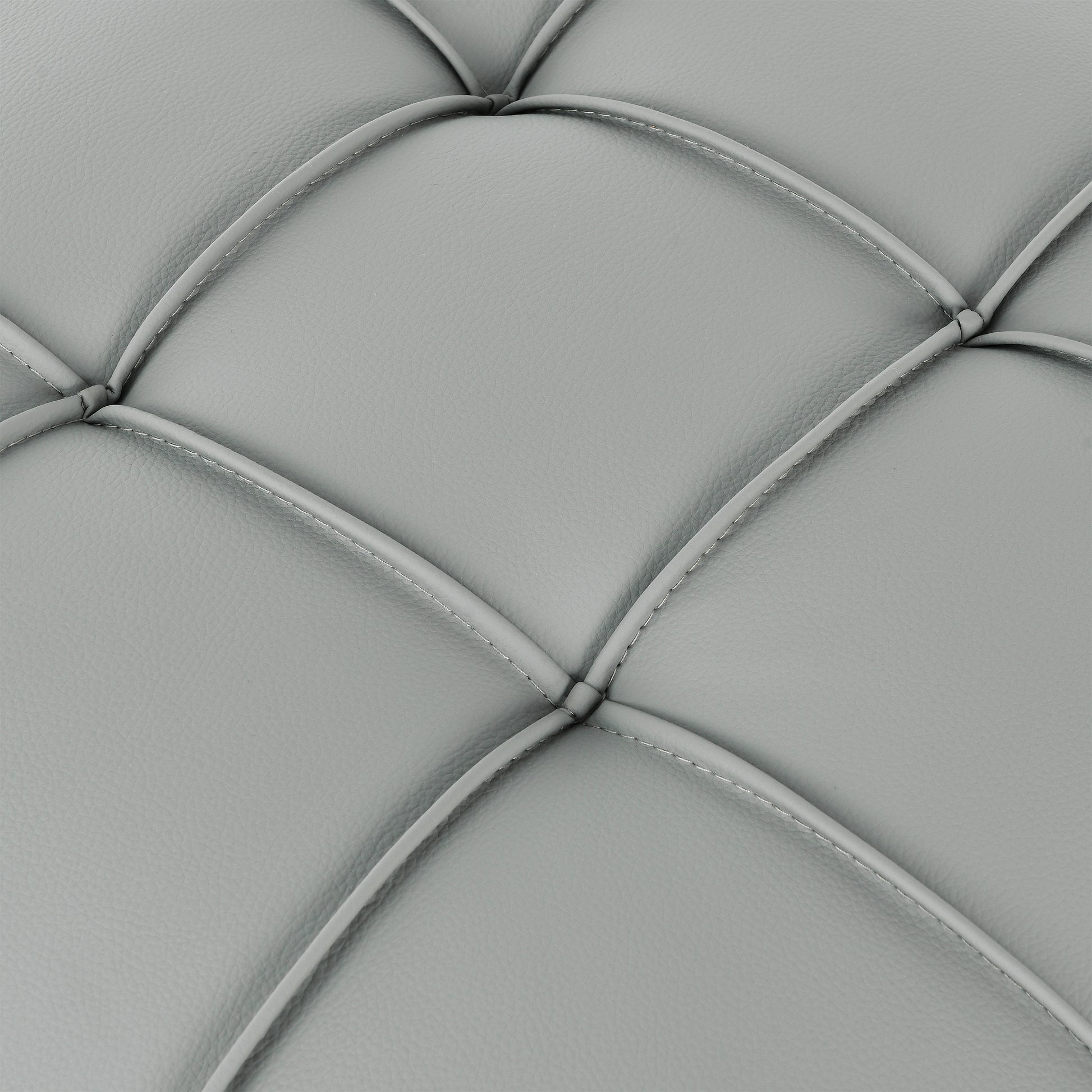 Closeup of grey faux leather upholstery with diamond tufting showcasing material texture