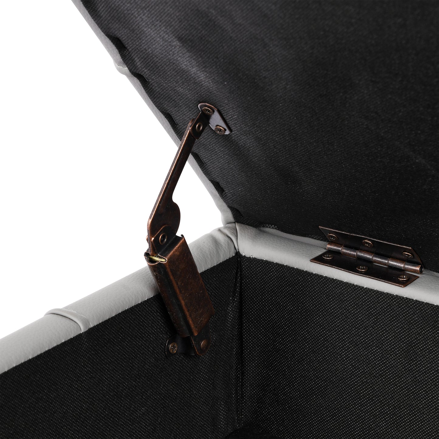 Closeup of antique bronze hinges on a grey faux leather storage ottoman
