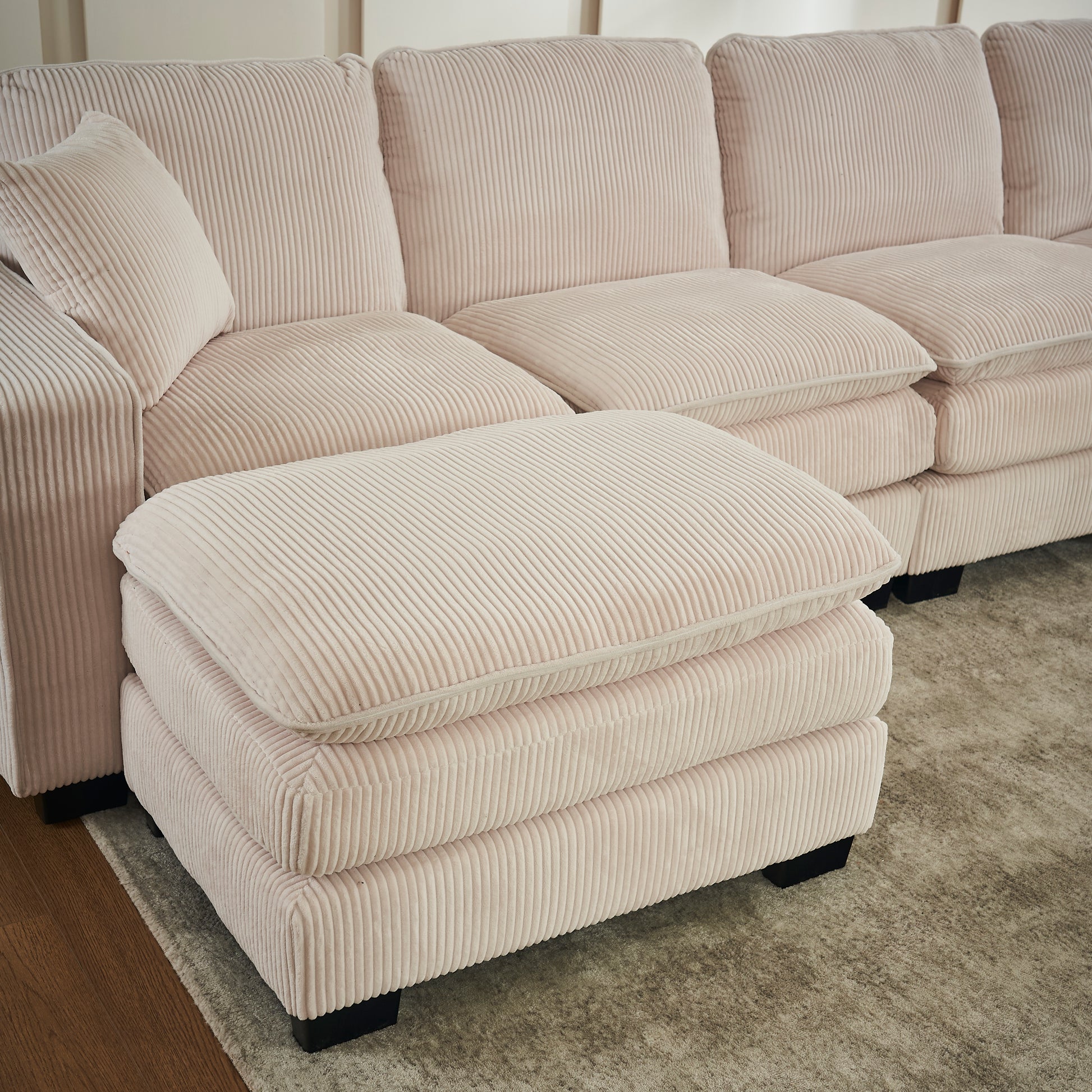 Plush pink corduroy sectional sofa with a matching ottoman perfect for living room comfort