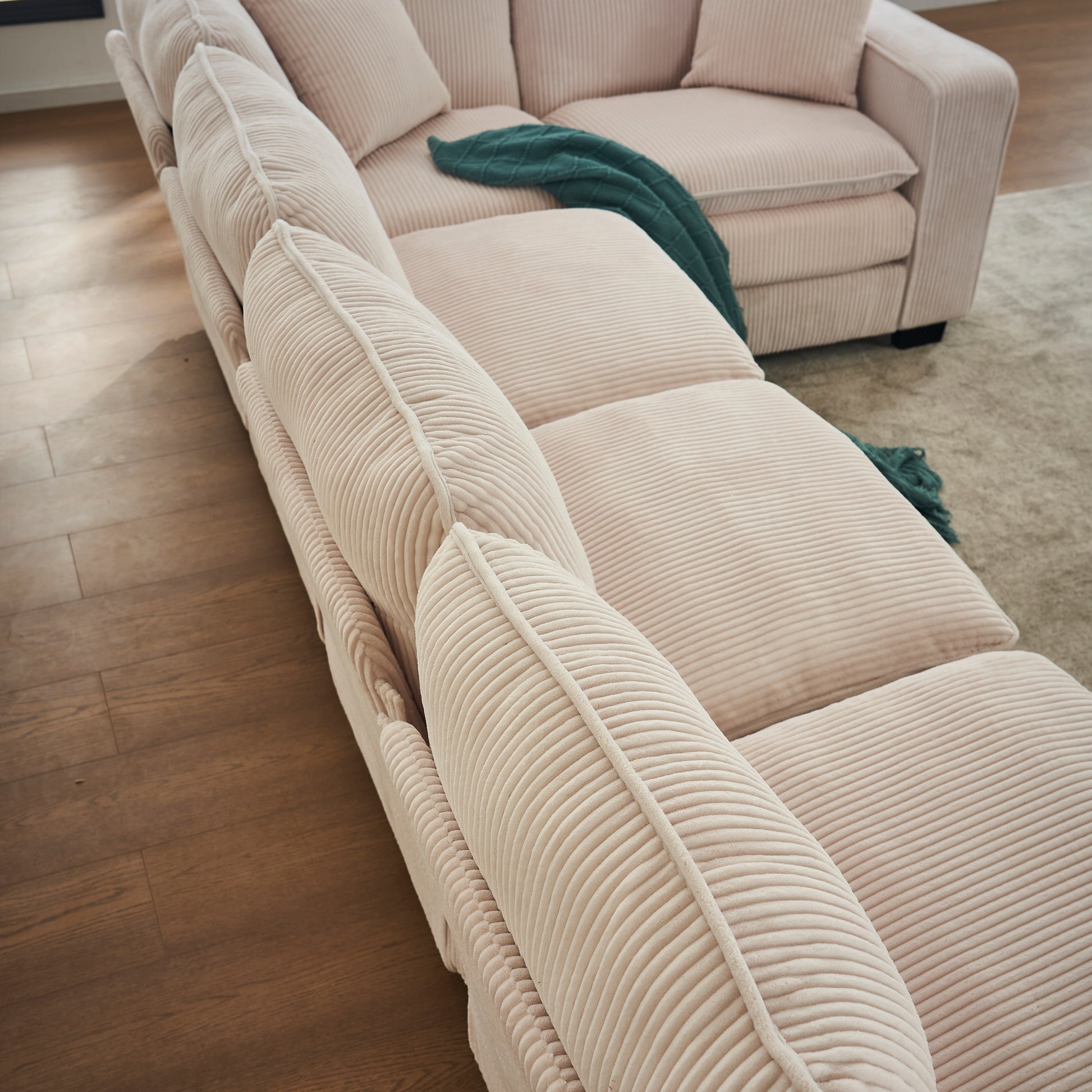 Plush cream corduroy sectional sofa with wide channeltufted cushions
