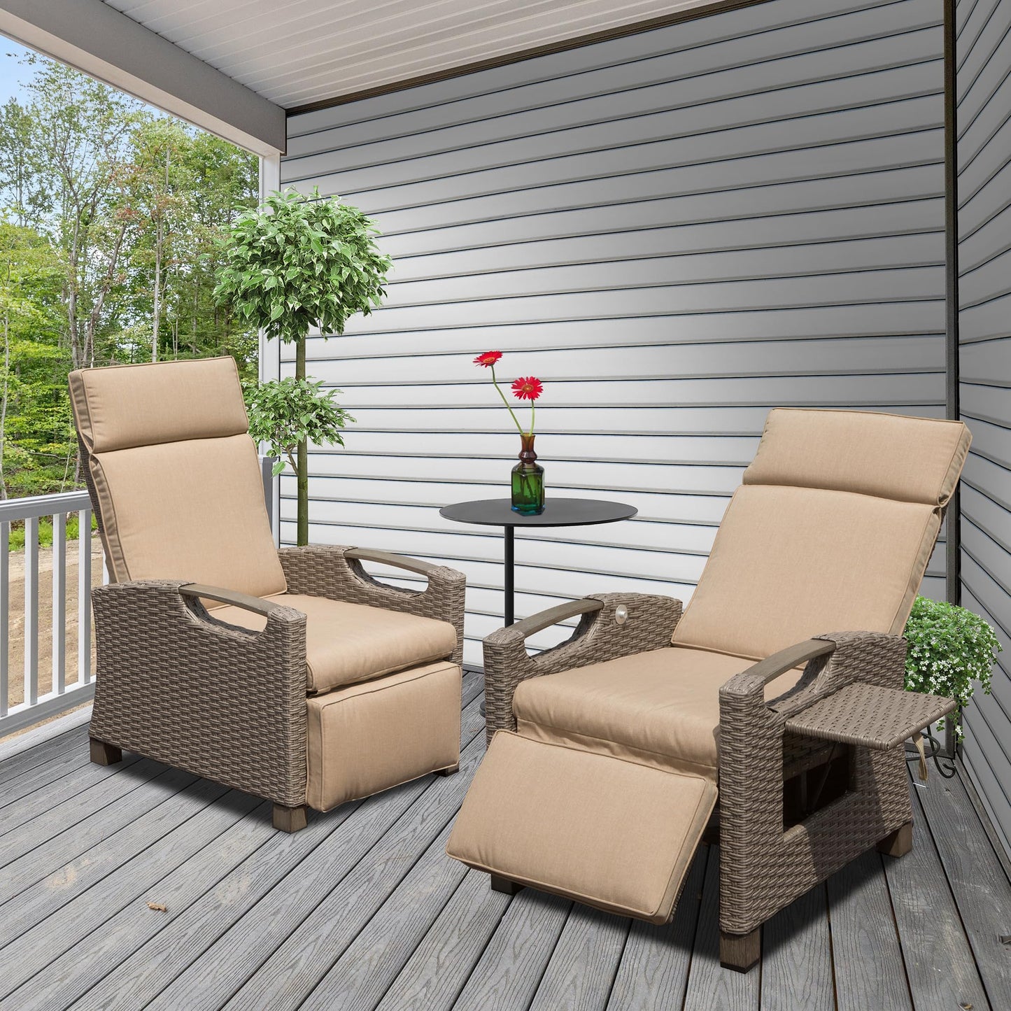Two beige cushioned wicker patio recliners with footrests and side tables on a wooden deck