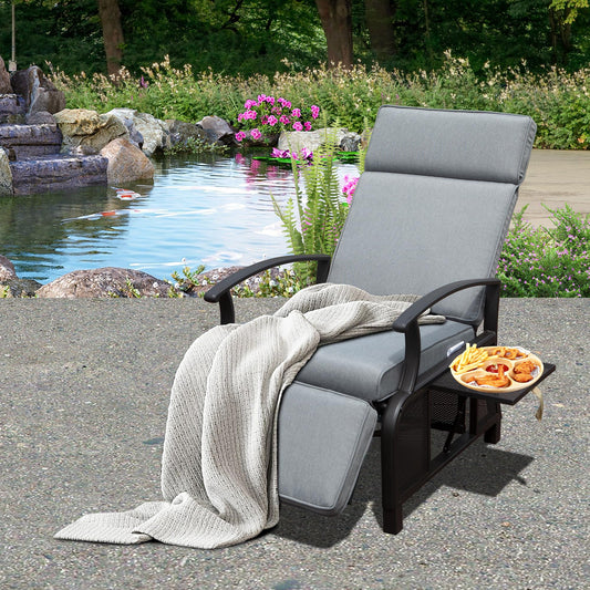 Gray outdoor reclining lounge chair with plush cushions and a side tray holding fried snacks