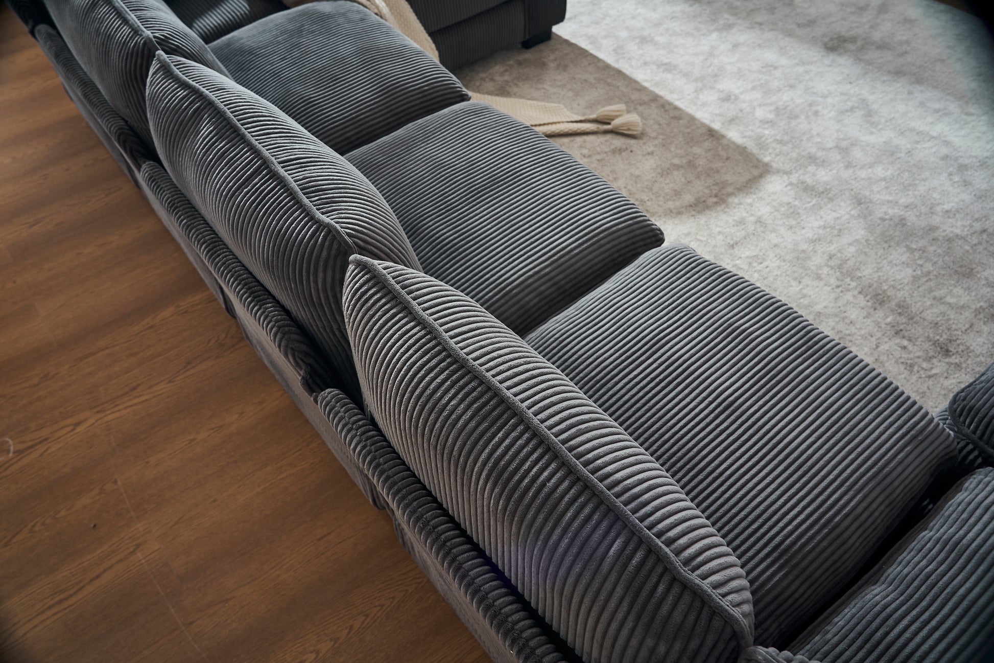 Deep charcoal corduroy sectional sofa with plush textured cushions