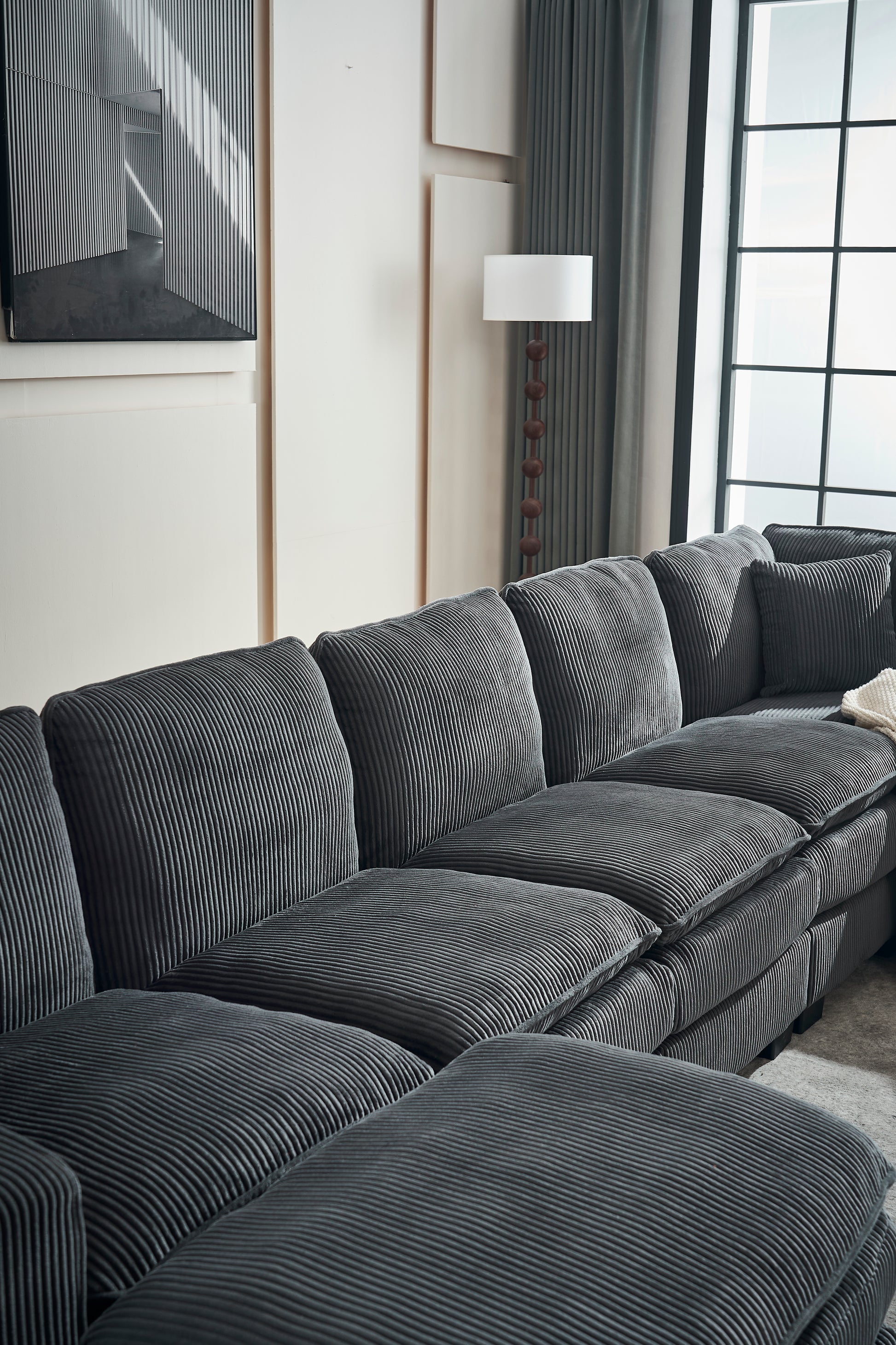 Deep charcoal sectional sofa with plush corduroy upholstery and thick cushions