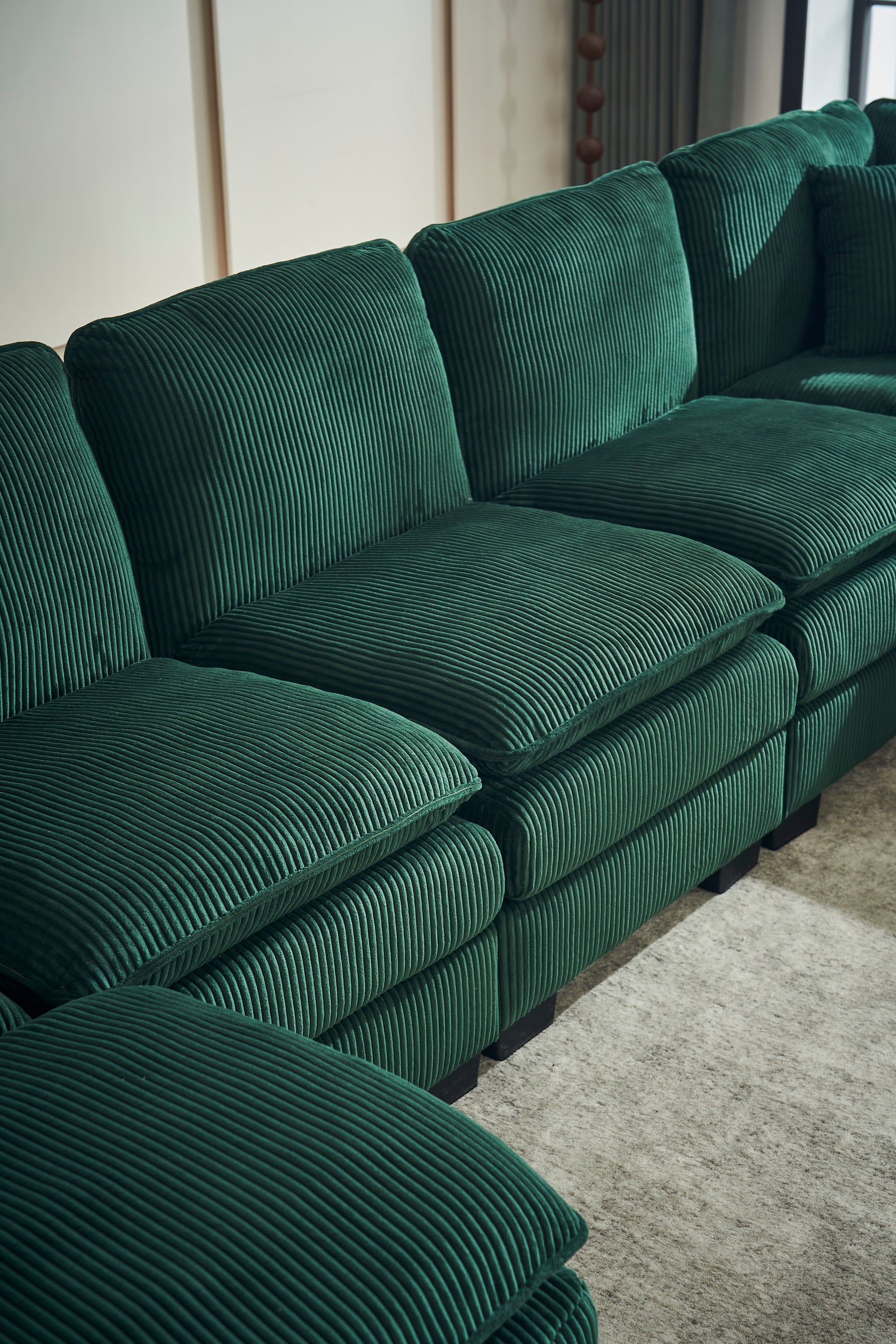 Deep green corduroy sectional sofa with plush textured cushions for a cozy living room