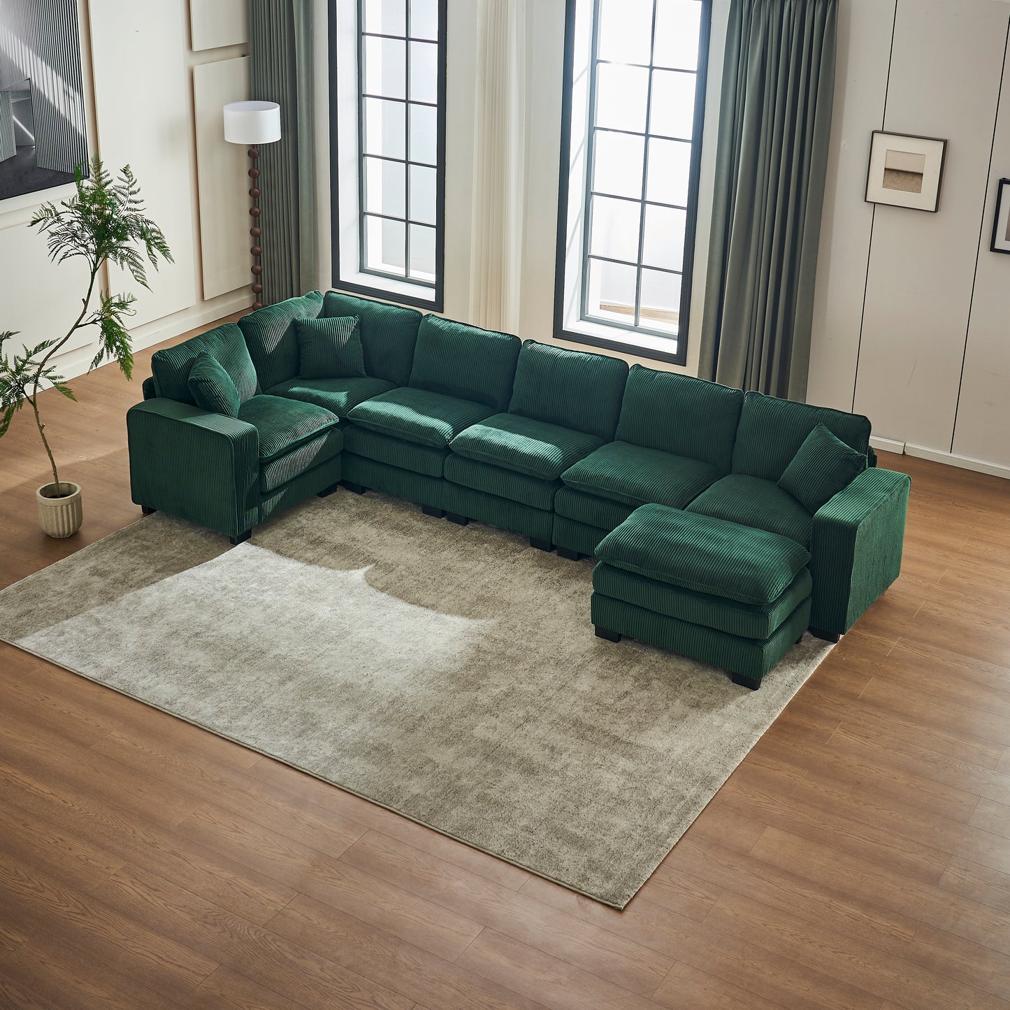 Deep green corduroy sectional sofa with plush cushions and an ottoman perfect for modern living rooms