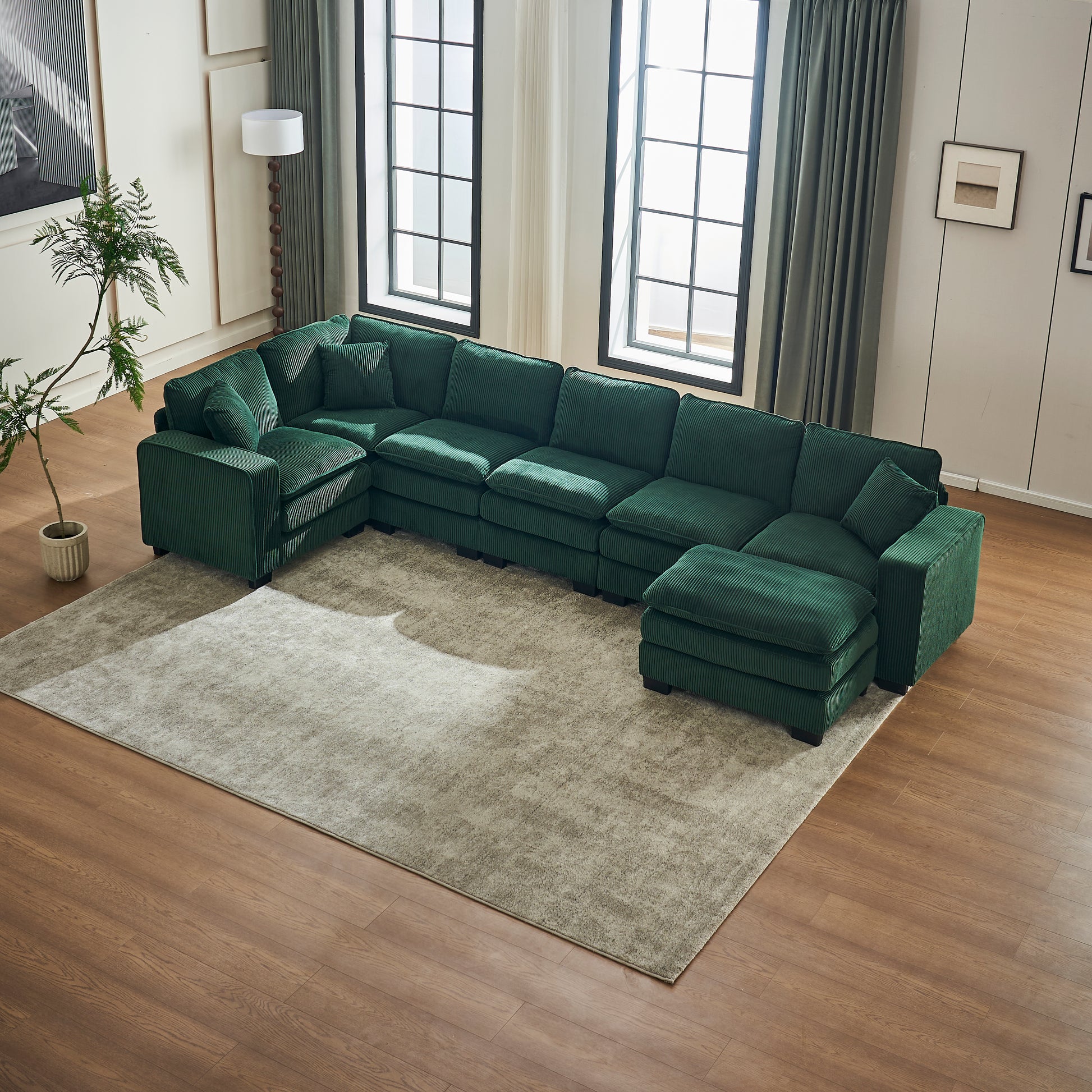 Deep green corduroy sectional sofa with plush cushions and an ottoman perfect for modern living rooms