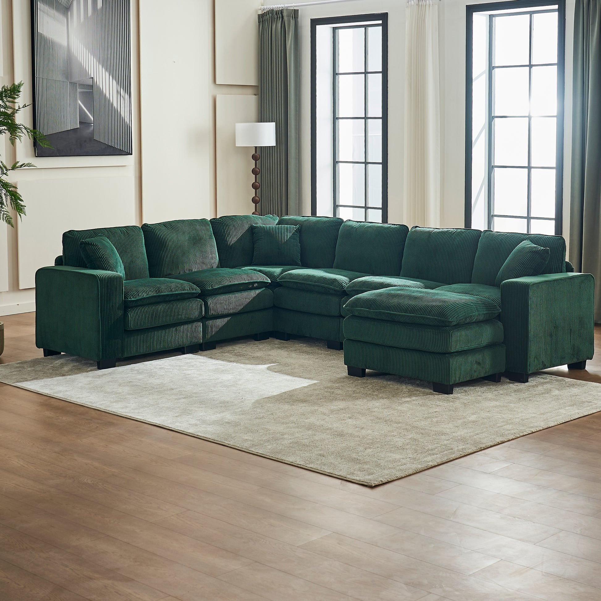 Emerald green corduroy sectional sofa with plush cushions and ottoman