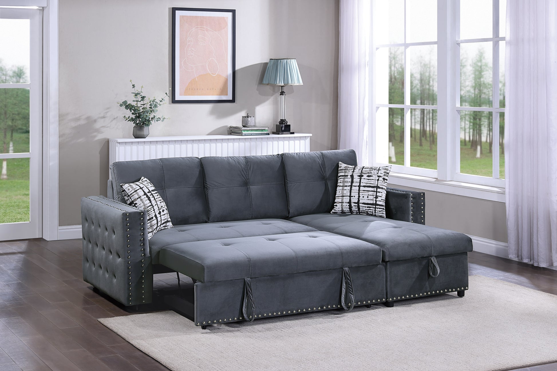 Dark grey velvet sectional sofa with pullout bed option and decorative nailhead trim