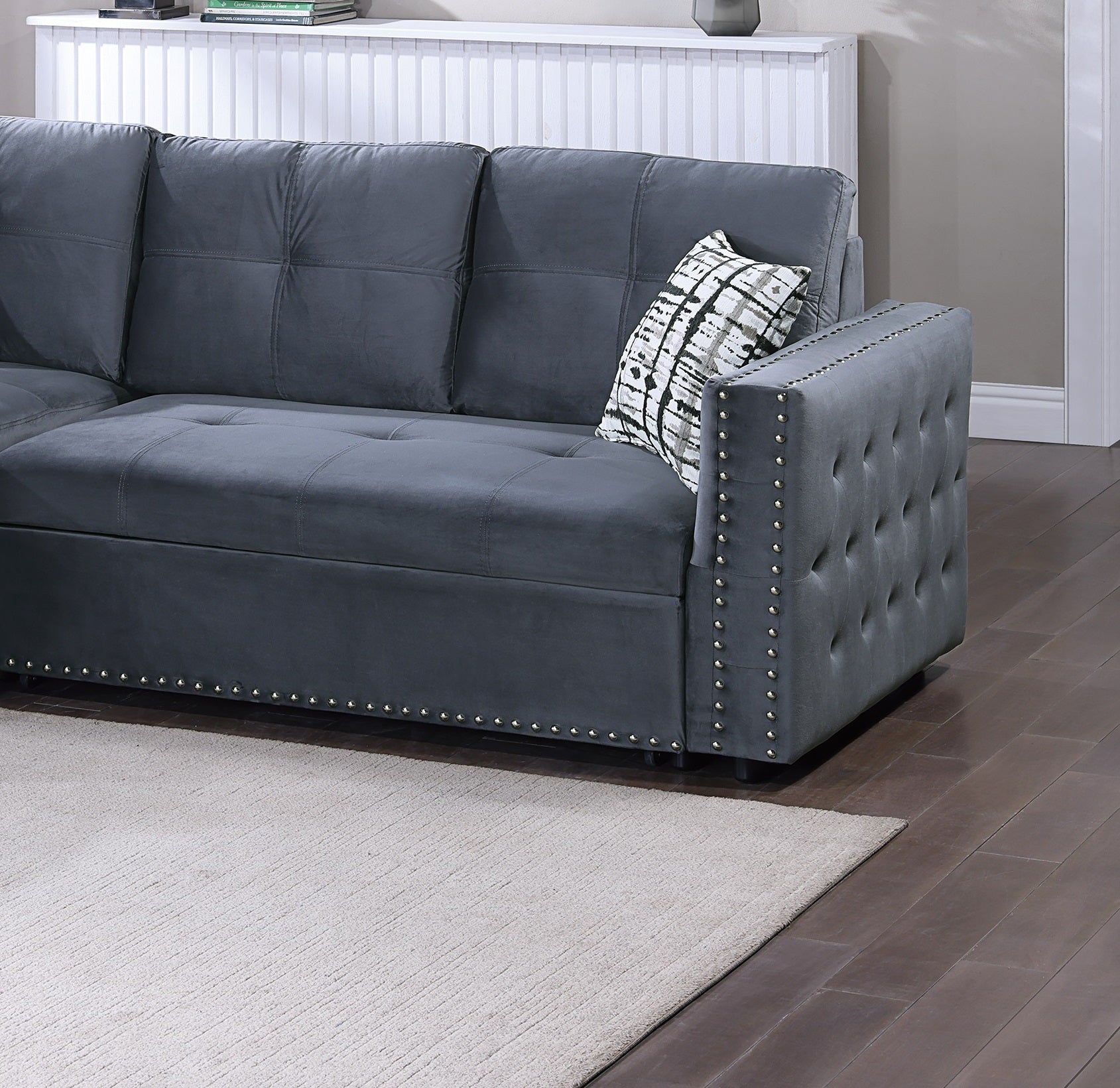 Dark gray velvet sectional sofa with tufted armrest and nailhead trim