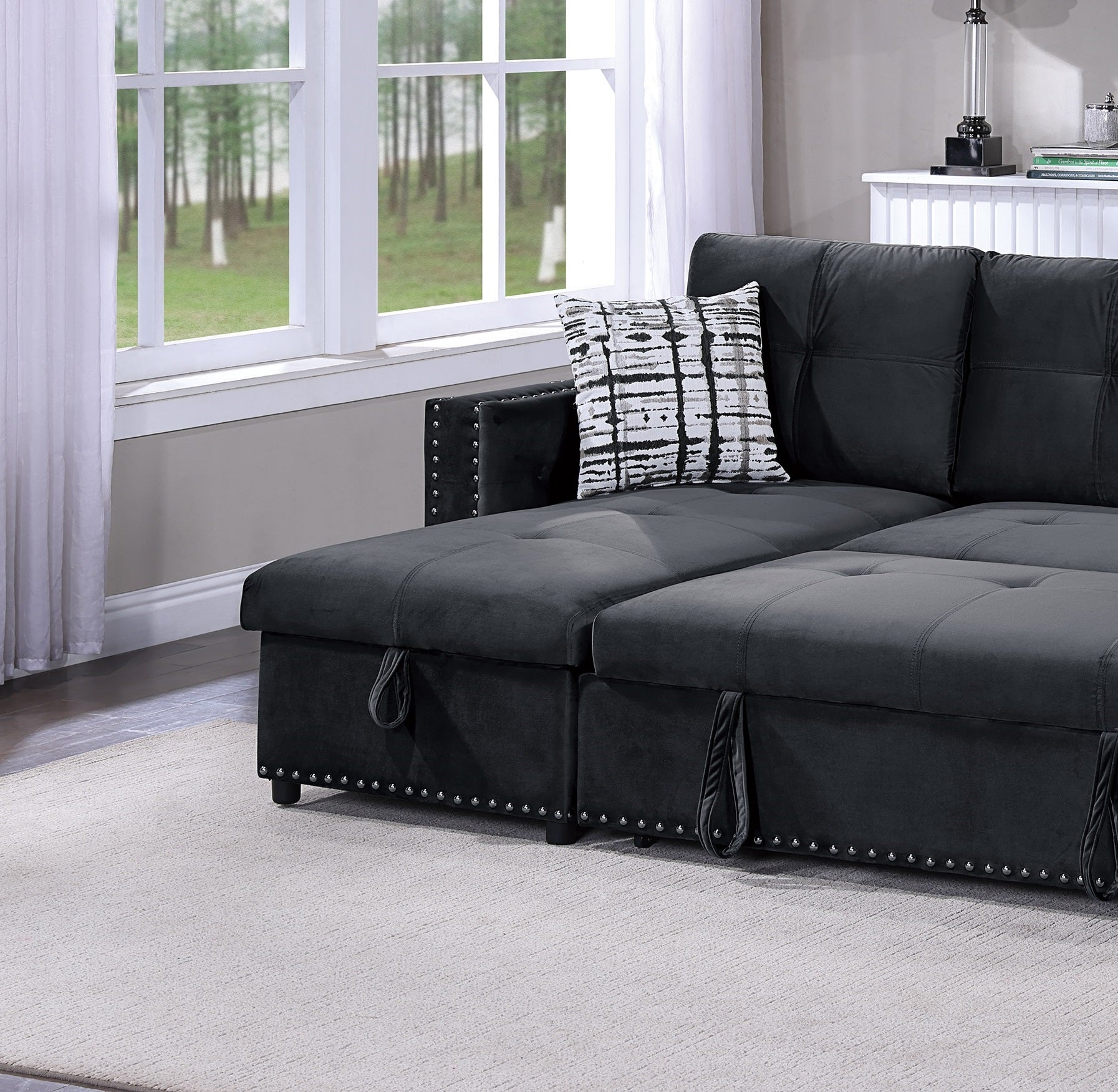 Dark gray velvet sectional sofa with tufted cushions and nailhead trim