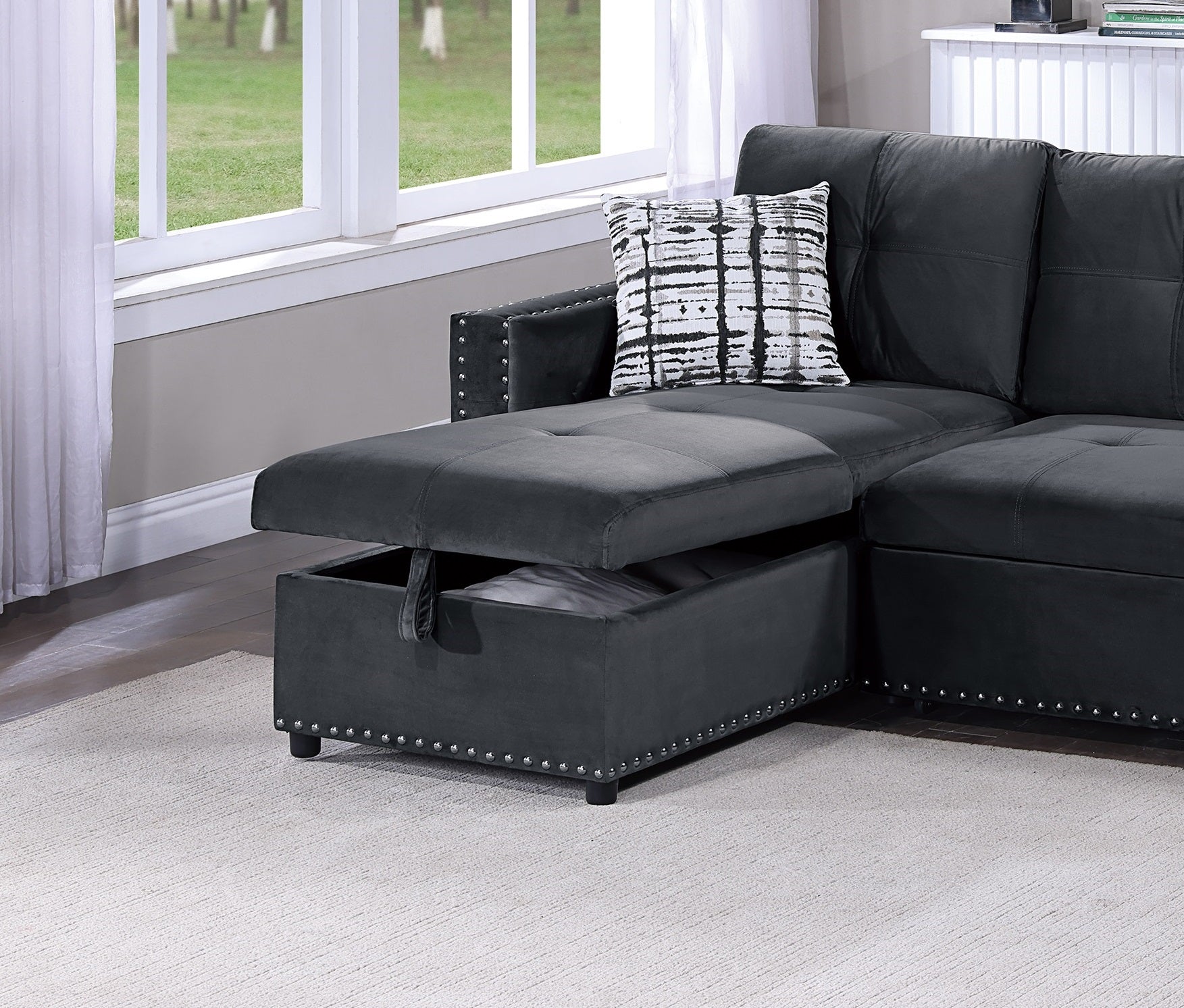 Dark gray velvet sectional sofa with hidden storage and silver nailhead trim detail