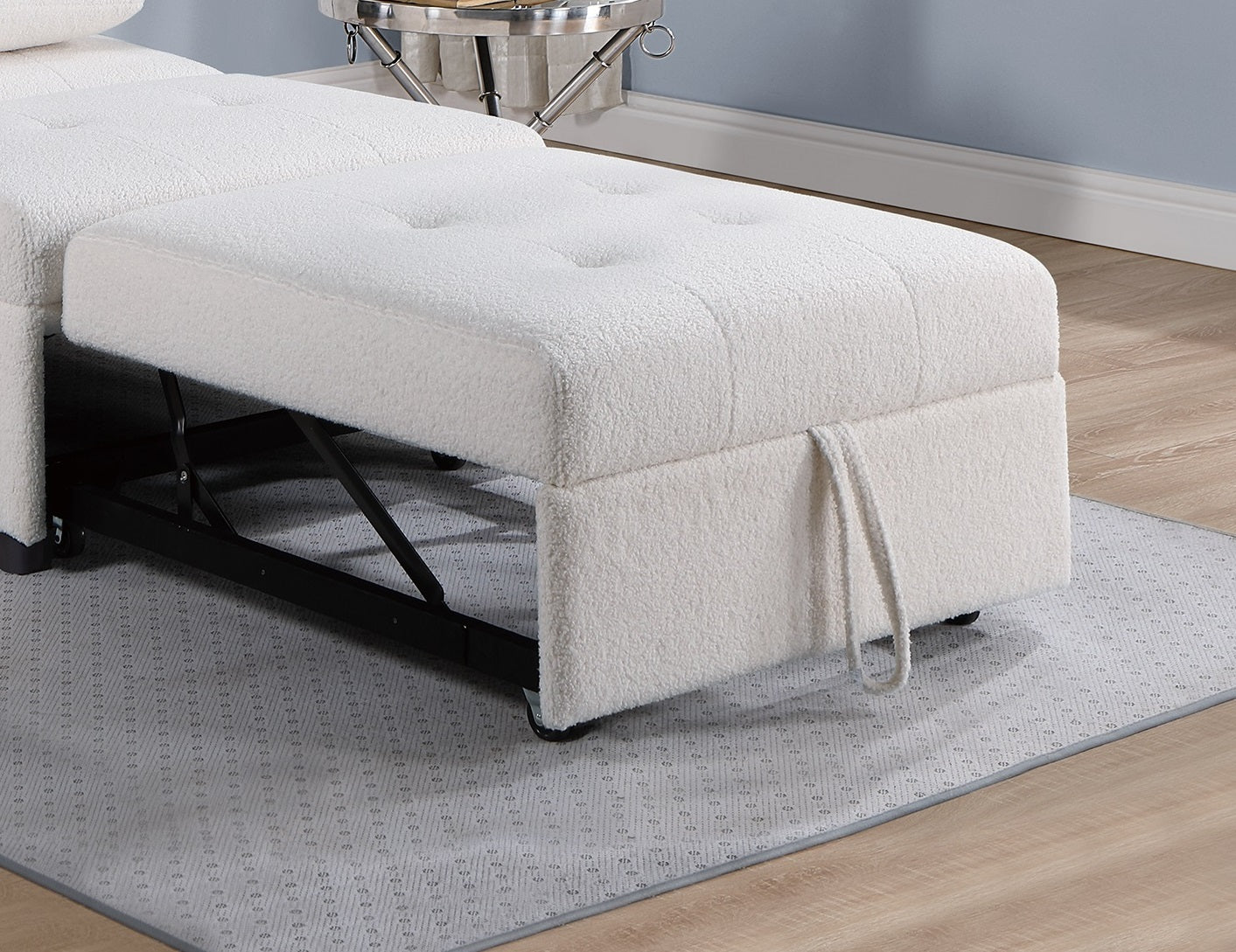 White boucle ottoman with tufted top and pull handle part of a sectional sofa