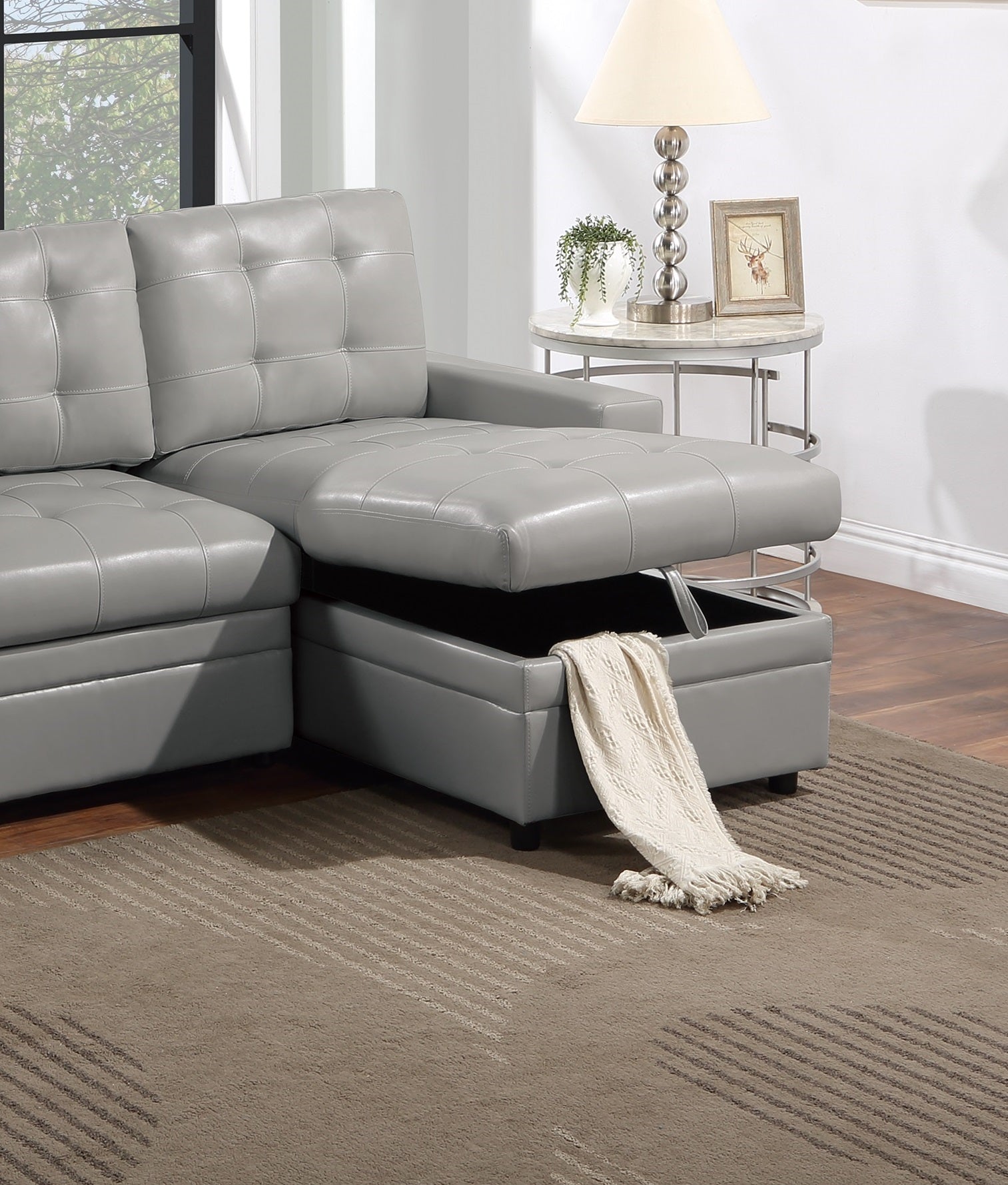 Gray faux leather sectional sofa with tufted cushions and hidden storage compartment