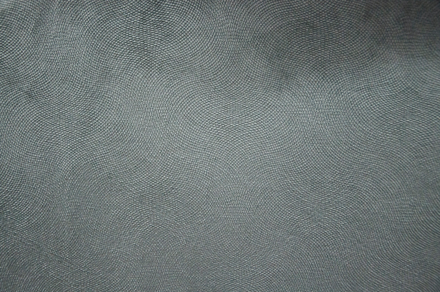 Closeup of a textured dark grey fabric with a subtle woven pattern