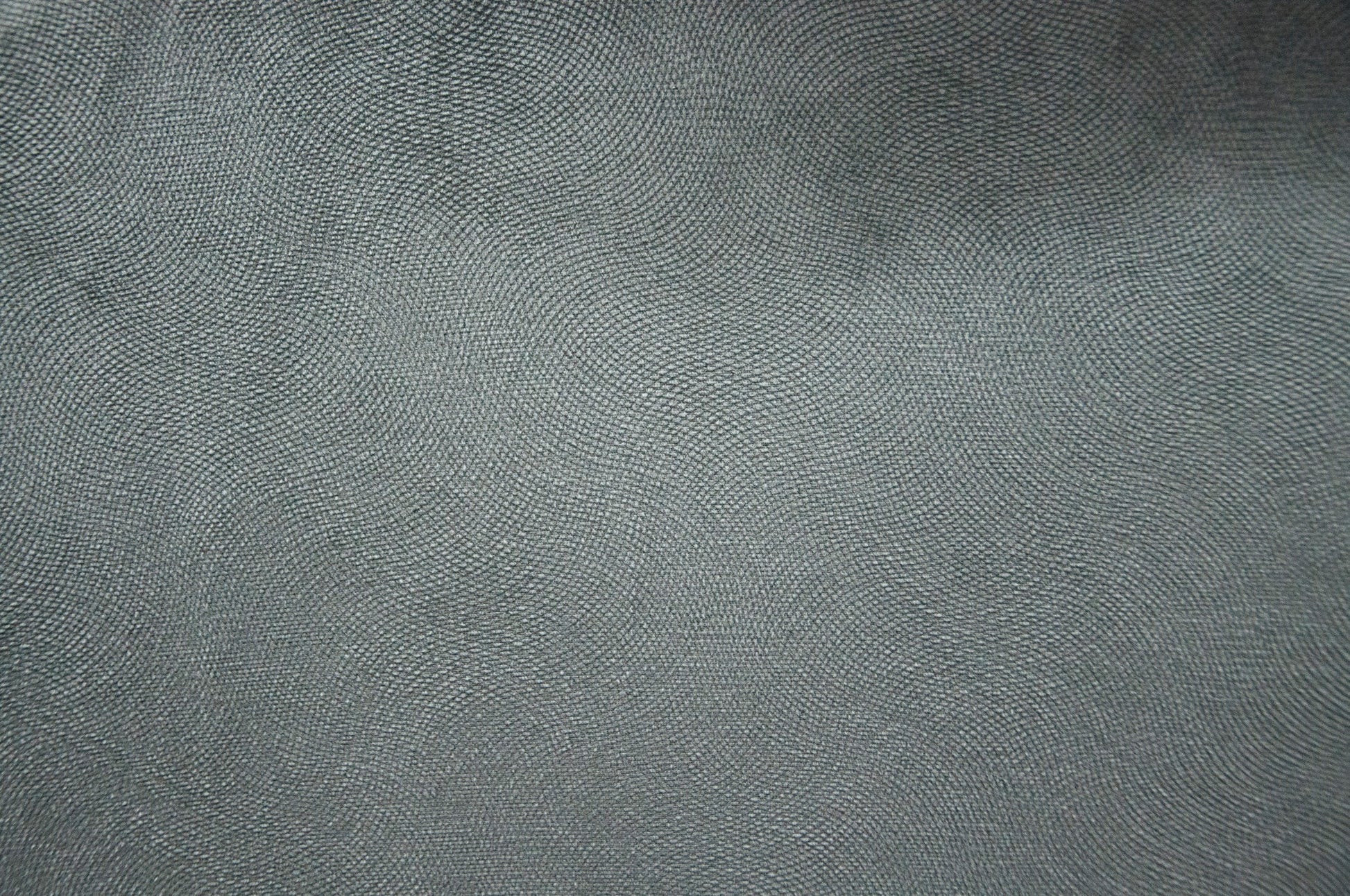Closeup of a textured dark grey fabric with a subtle woven pattern